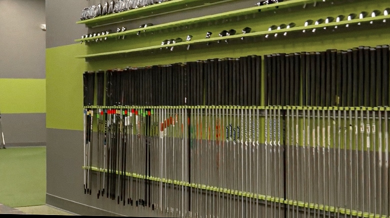 Golf clubs neatly arranged on wall display