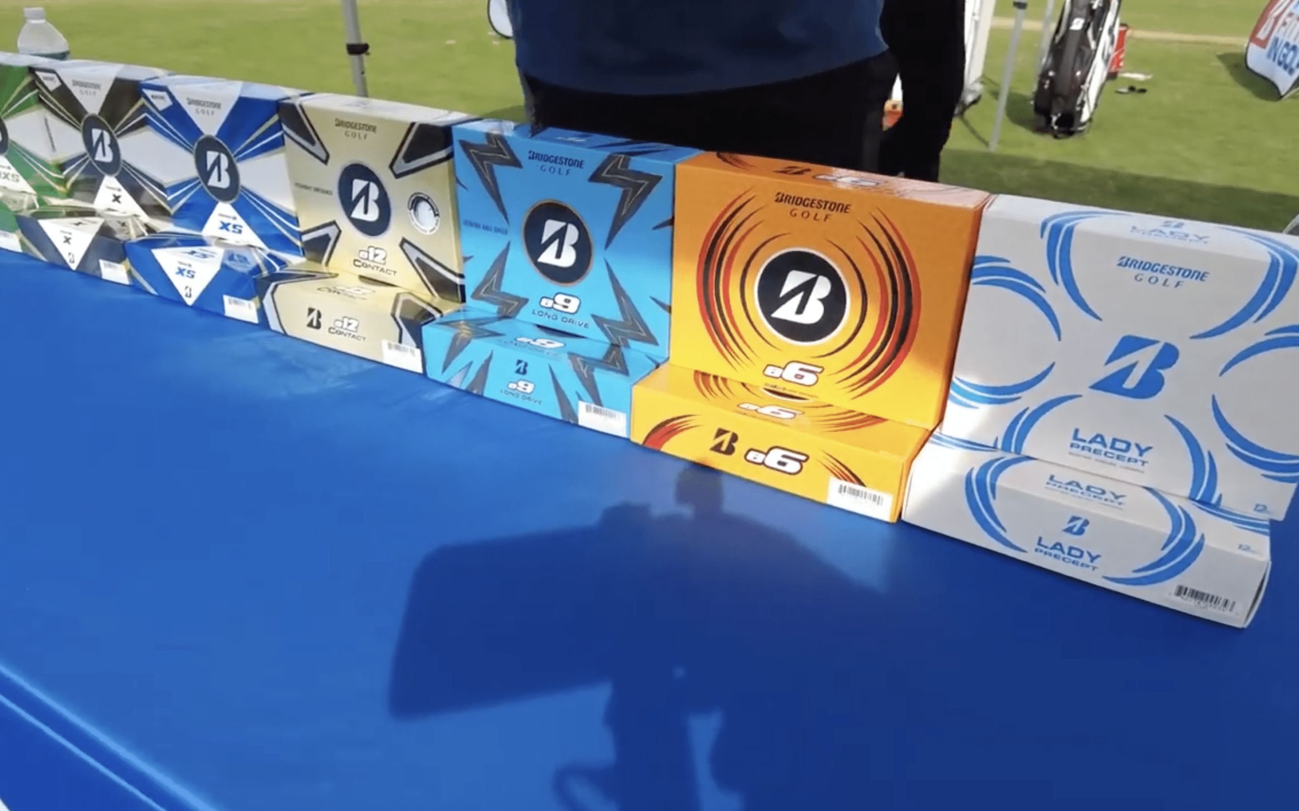 Bridgestone golf balls displayed on blue table.