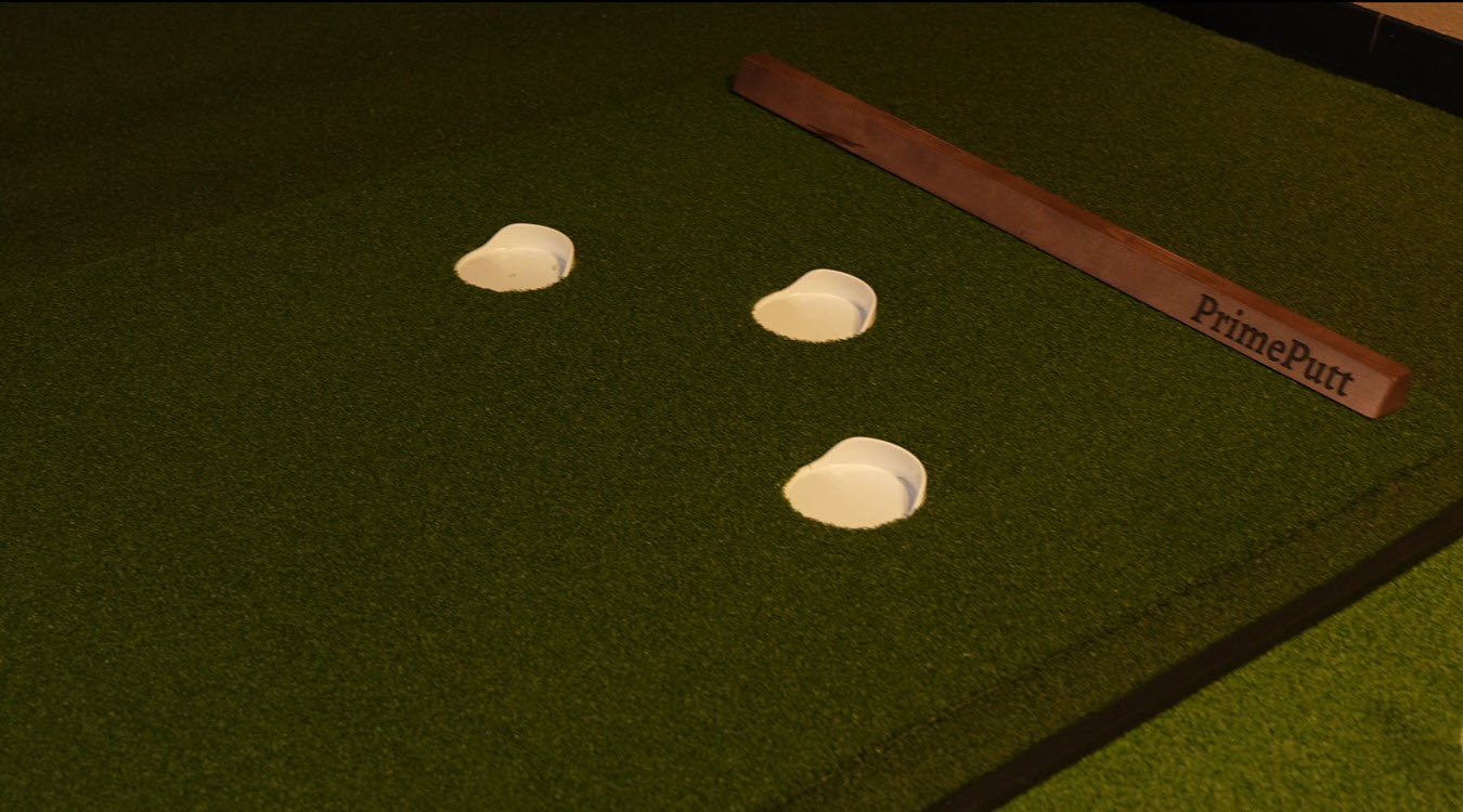 Indoor putting green with three holes and wooden putter