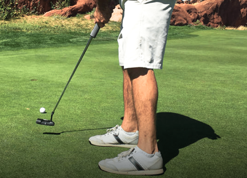 Golfer preparing to putt on the green.