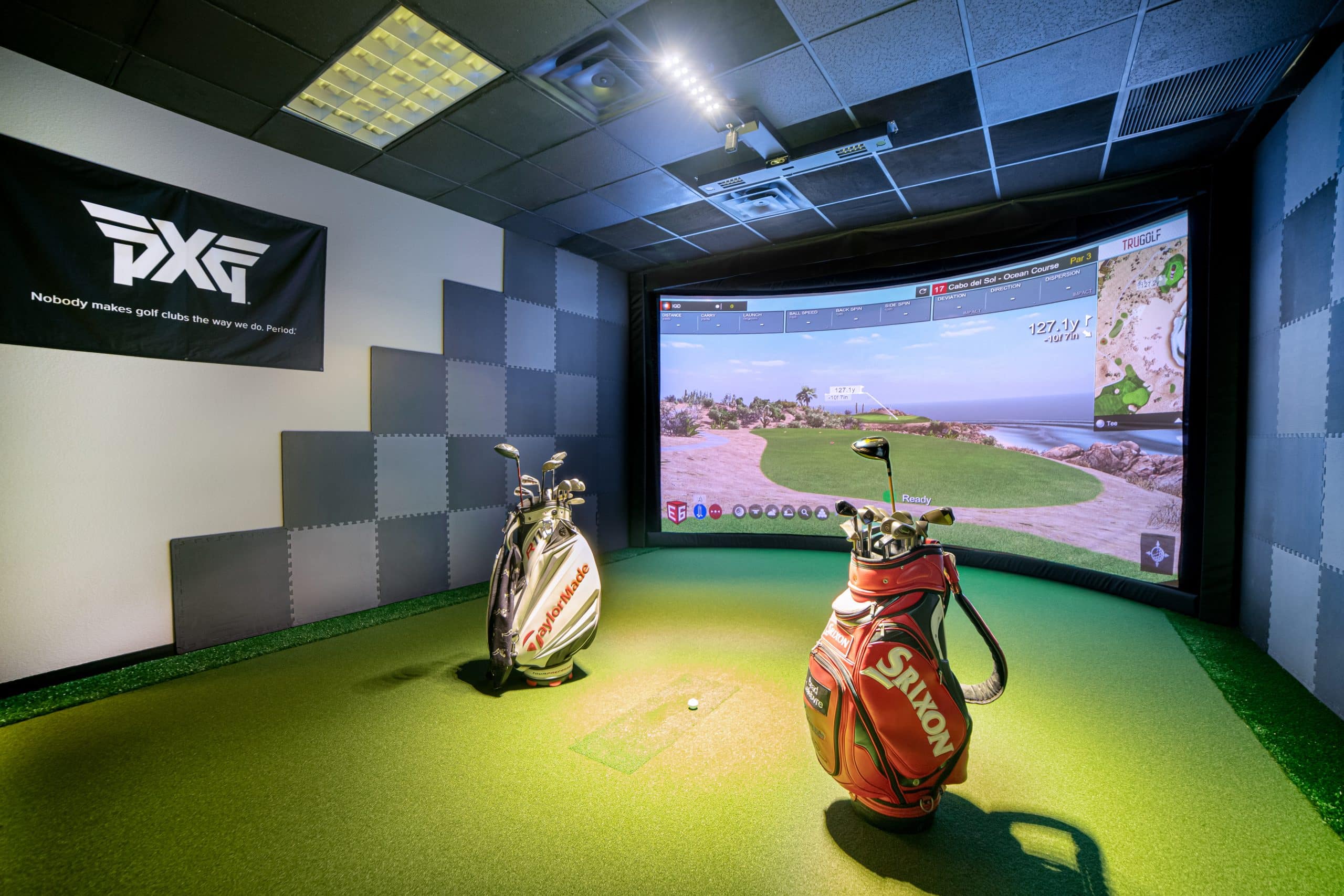 Indoor golf simulator with two golf bags