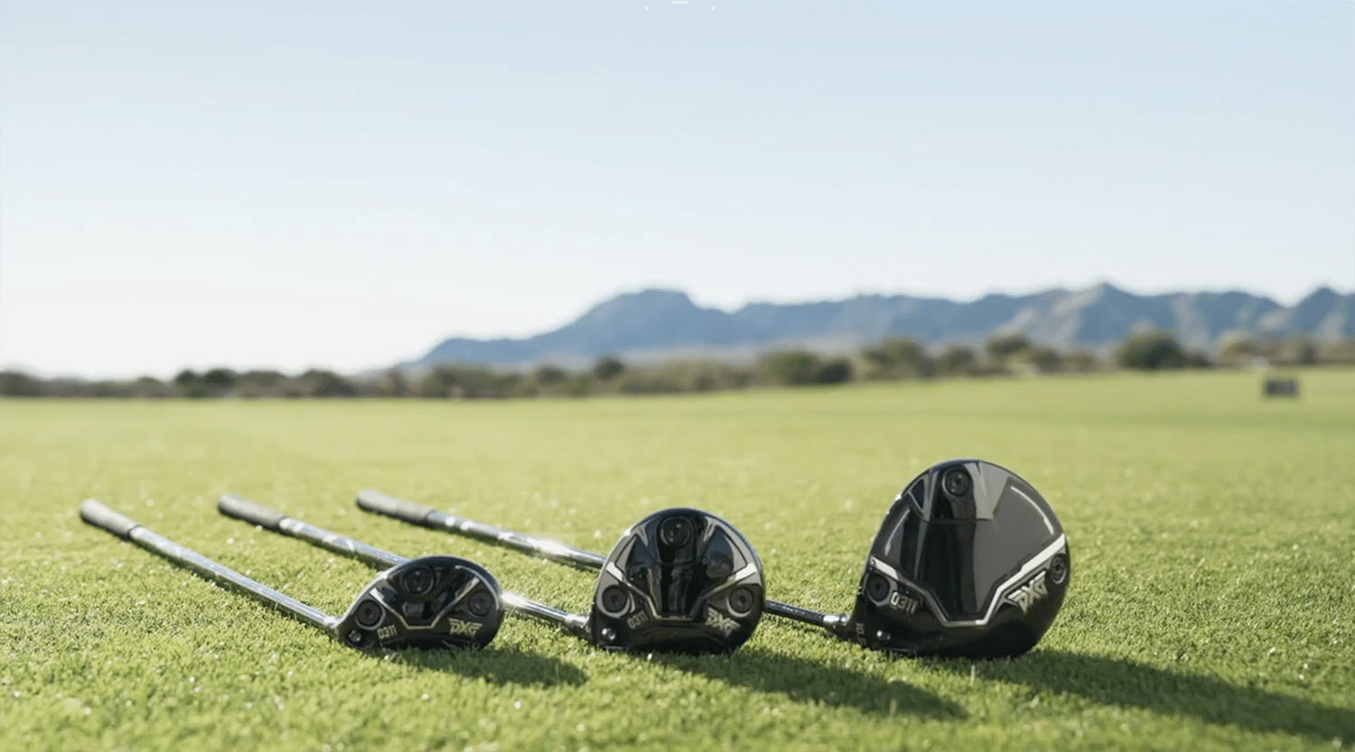 Four golf clubs on a sunny green lawn.