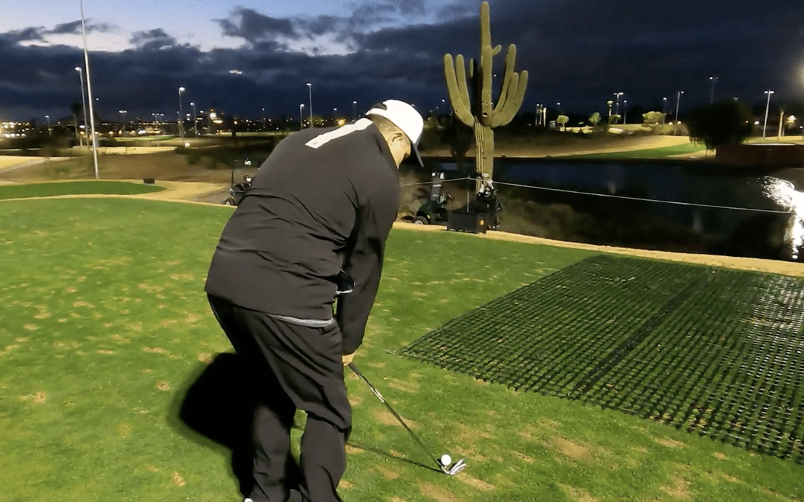 Golfer preparing to take a shot at dusk.