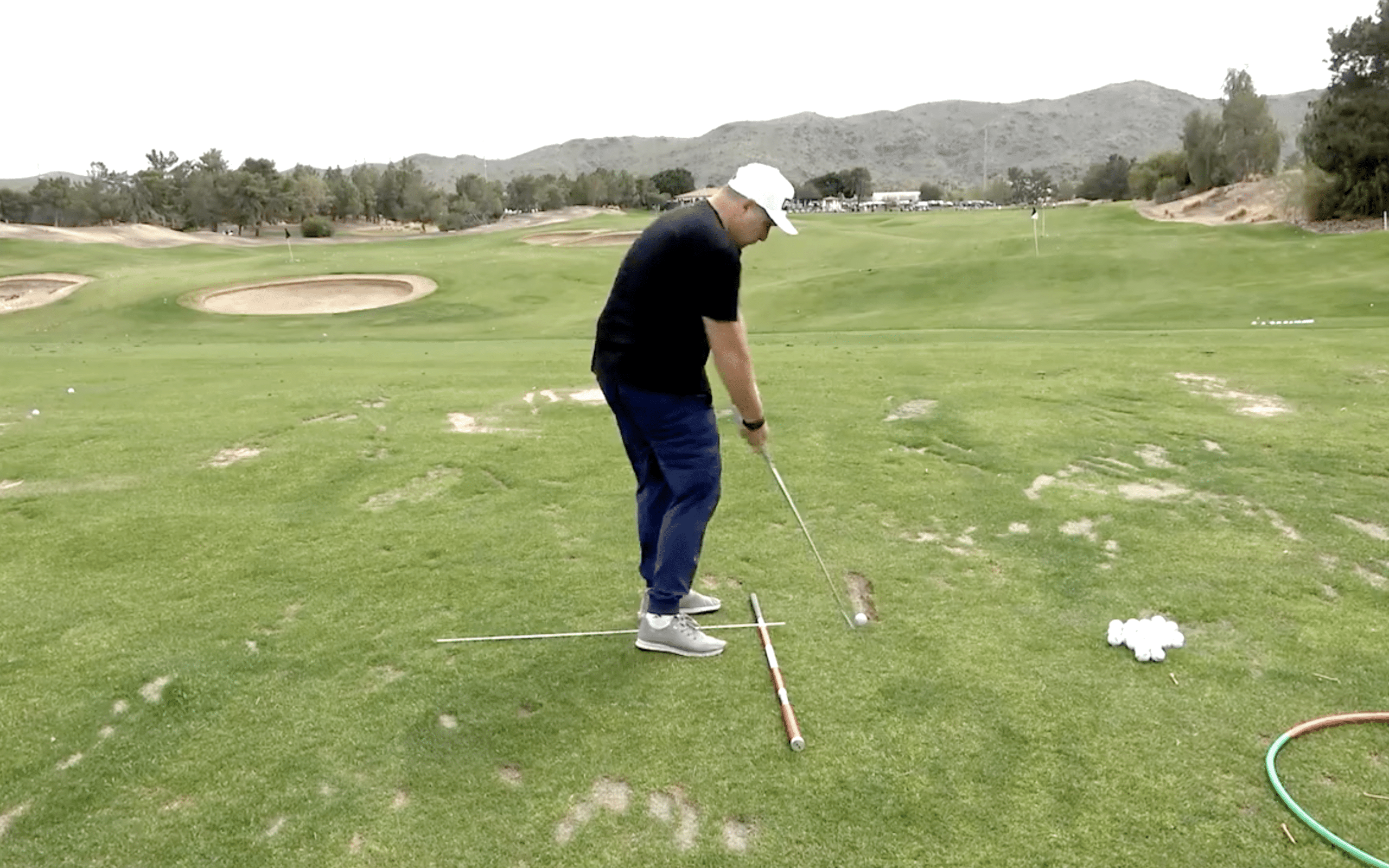 Person practicing golf swing on a green course.