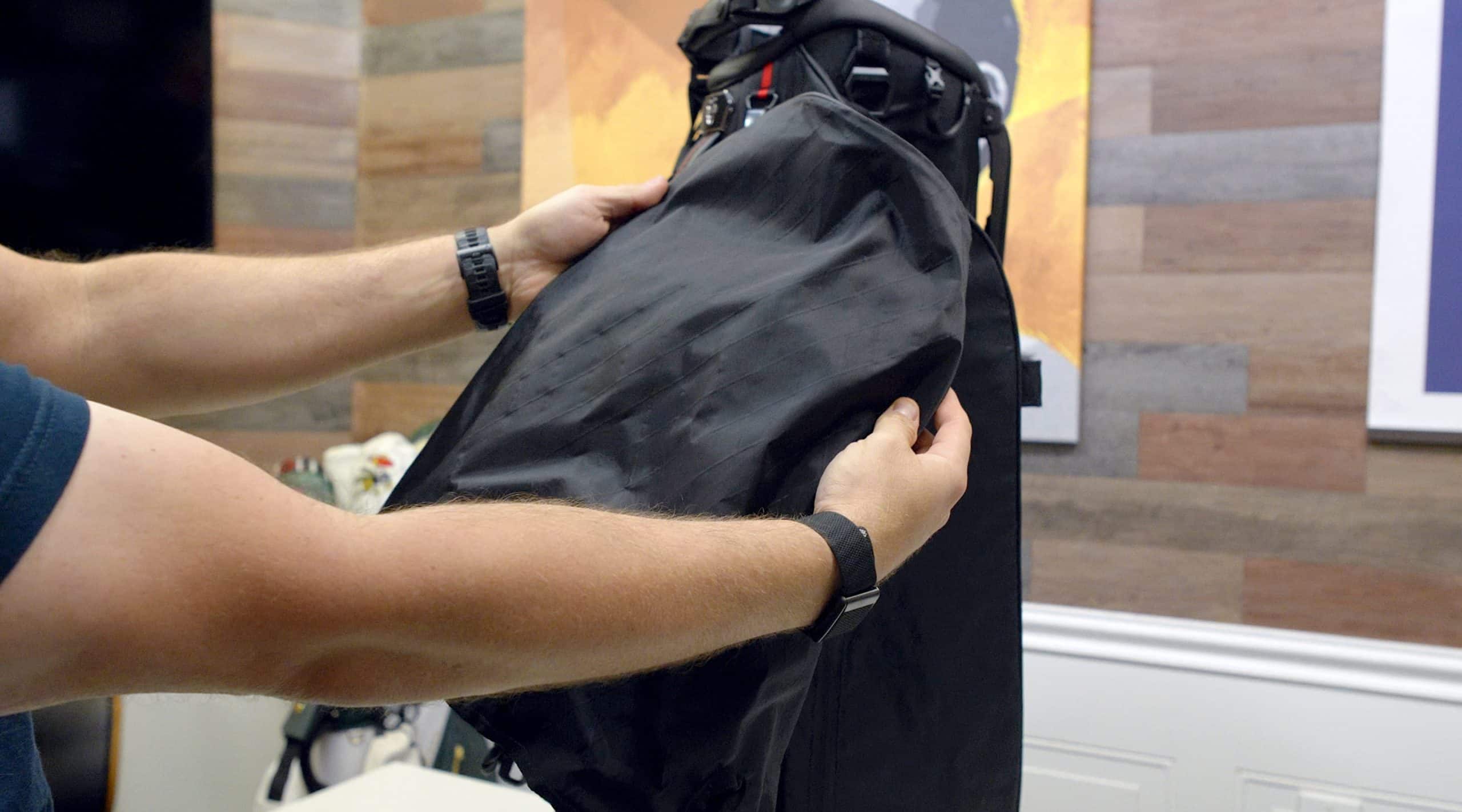 Person holding a black bag with hands.