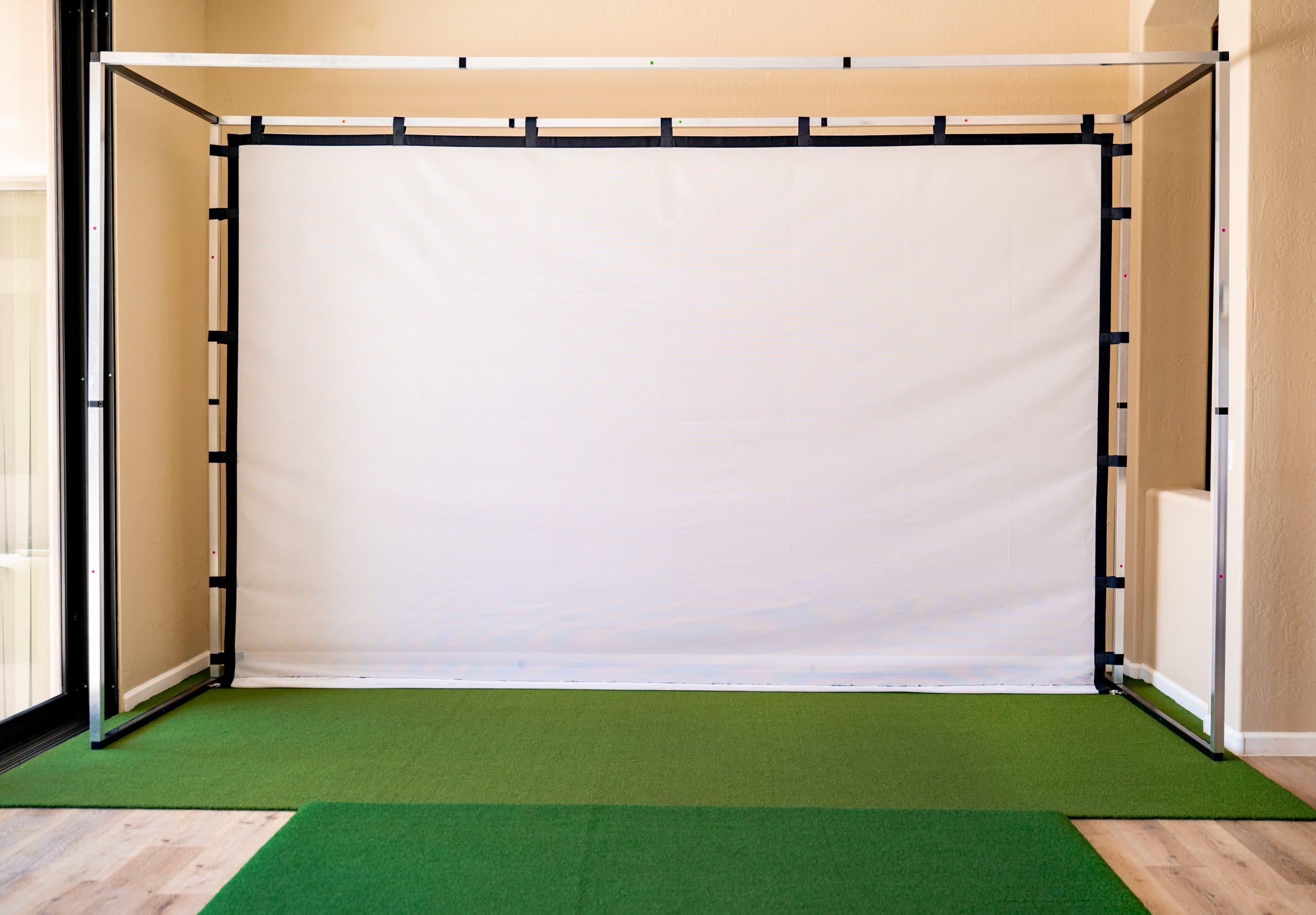 Indoor golf simulator with impact screen and turf