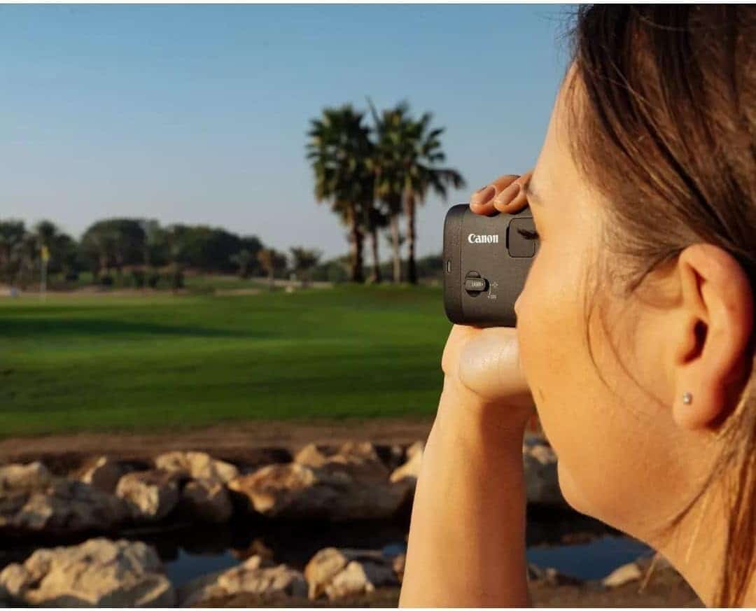 Woman using rangefinder on golf course