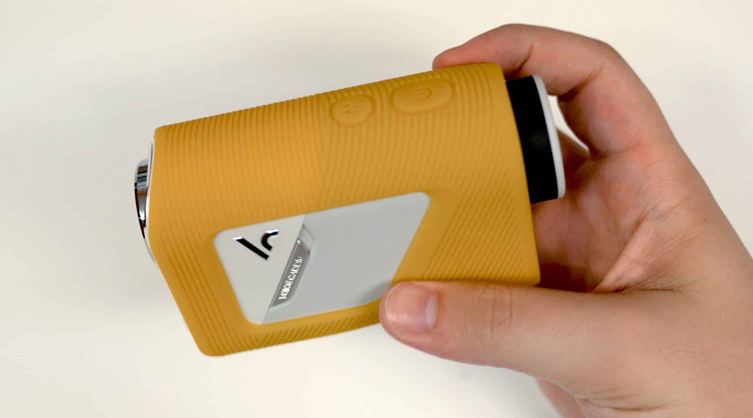 Hand holding yellow action camera with buttons