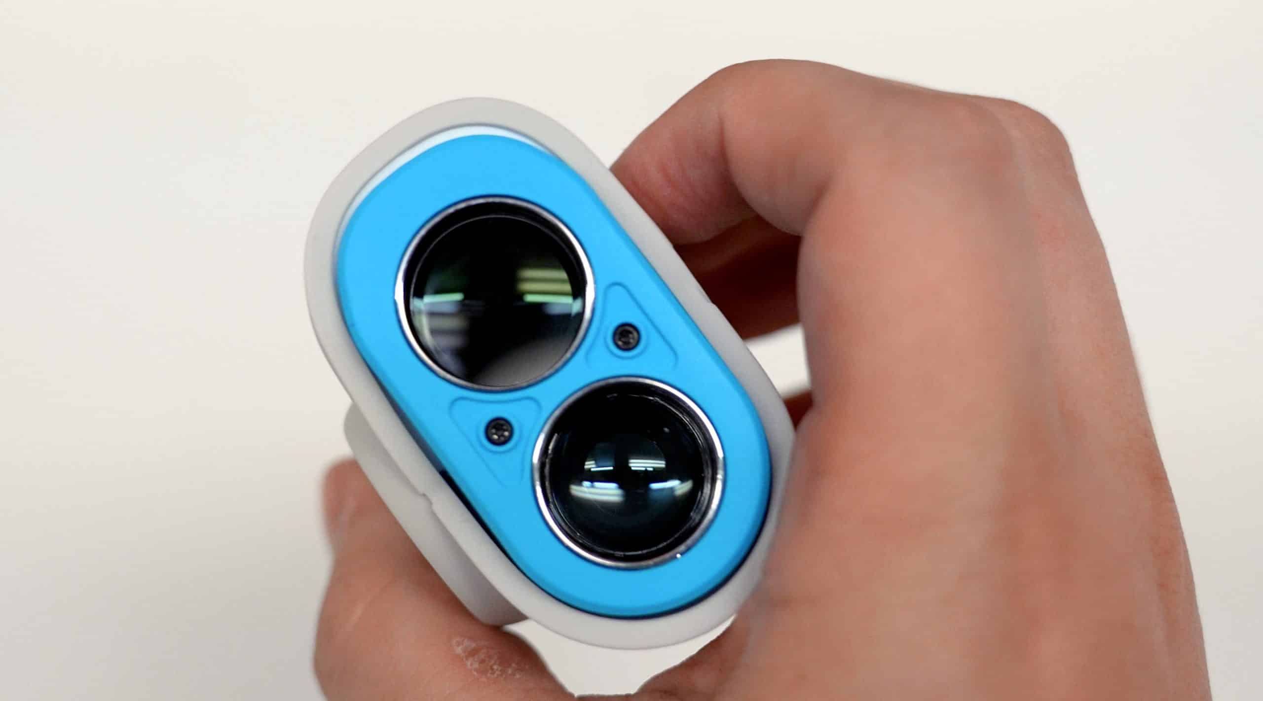Hand holding blue optical rangefinder device