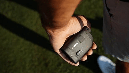 Hand holding Canon rangefinder outdoors