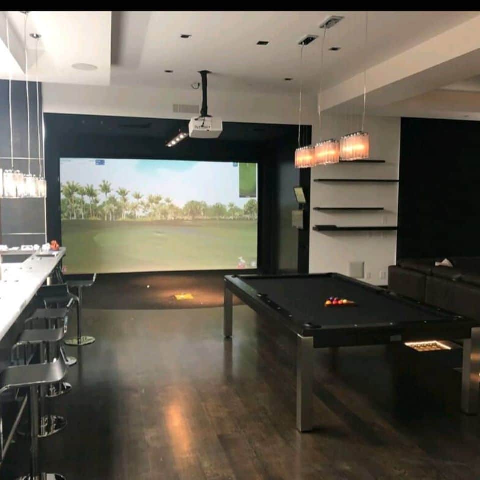 Modern game room with pool table and golf simulator
