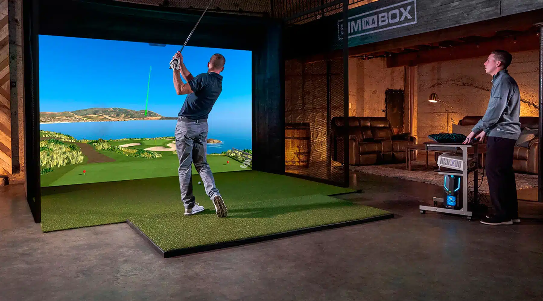 Man playing golf simulator indoors with large screen