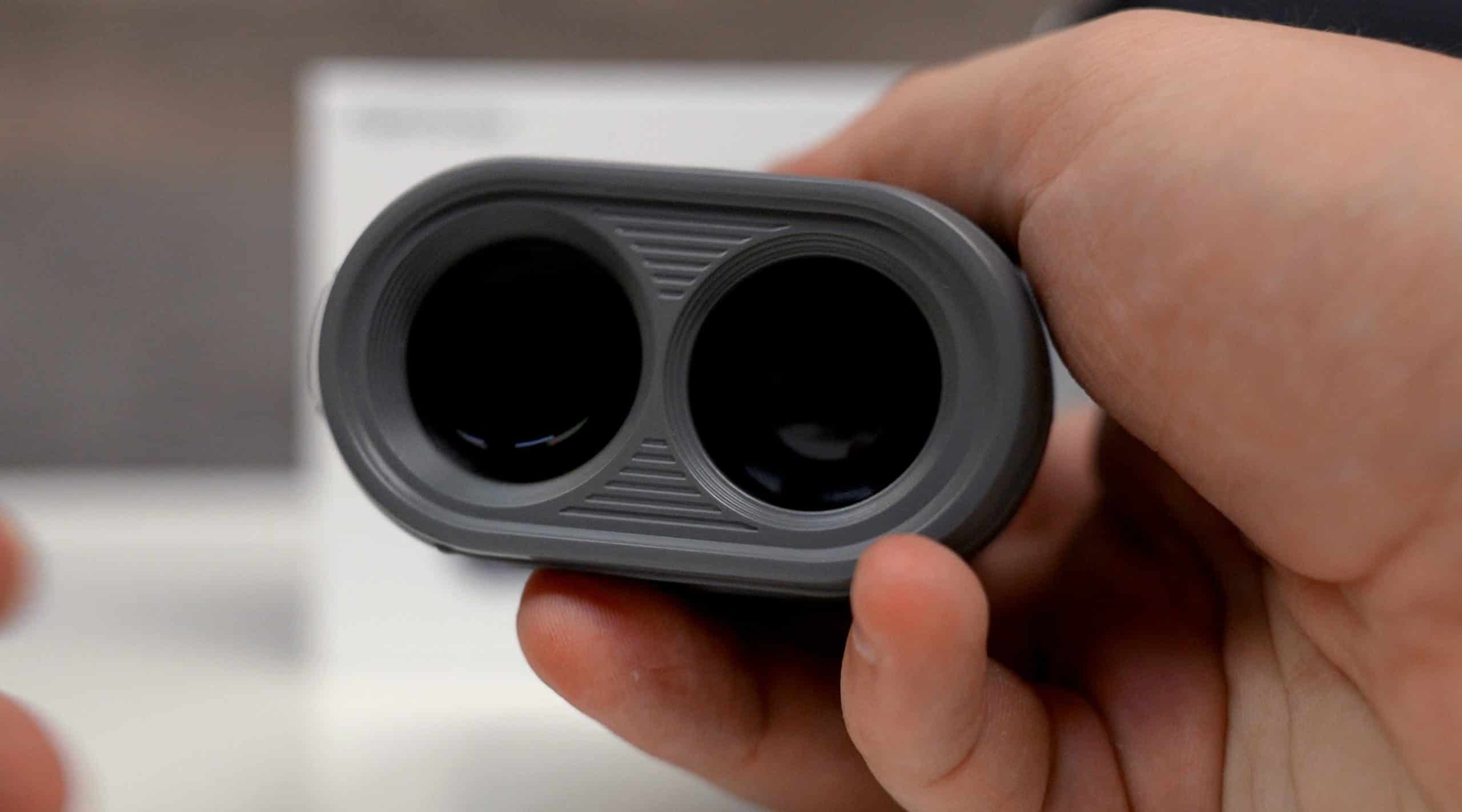 Hand holding a dual-lens optical device