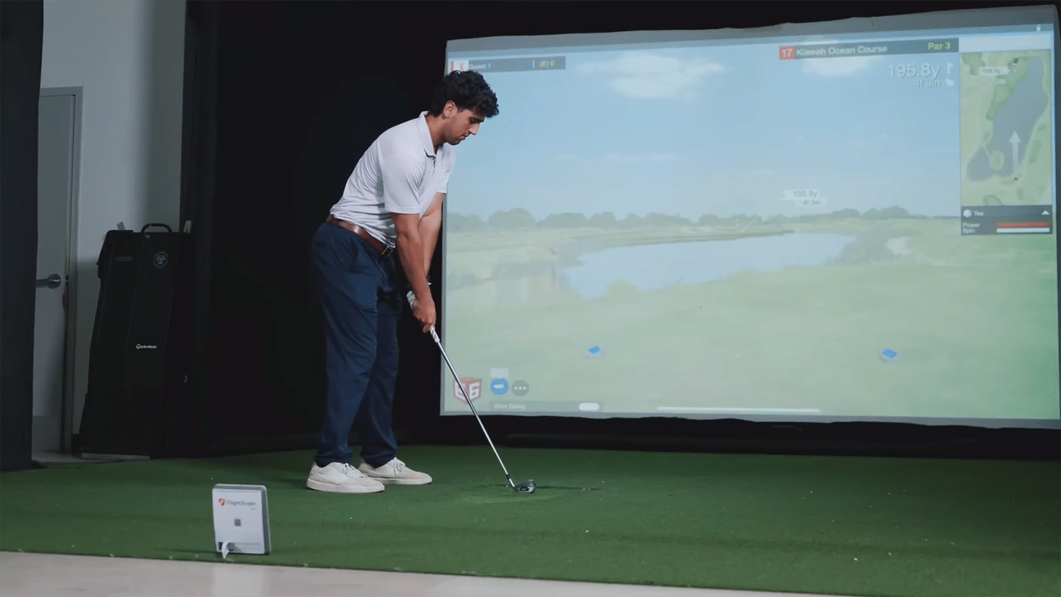 Man playing golf on indoor simulator screen