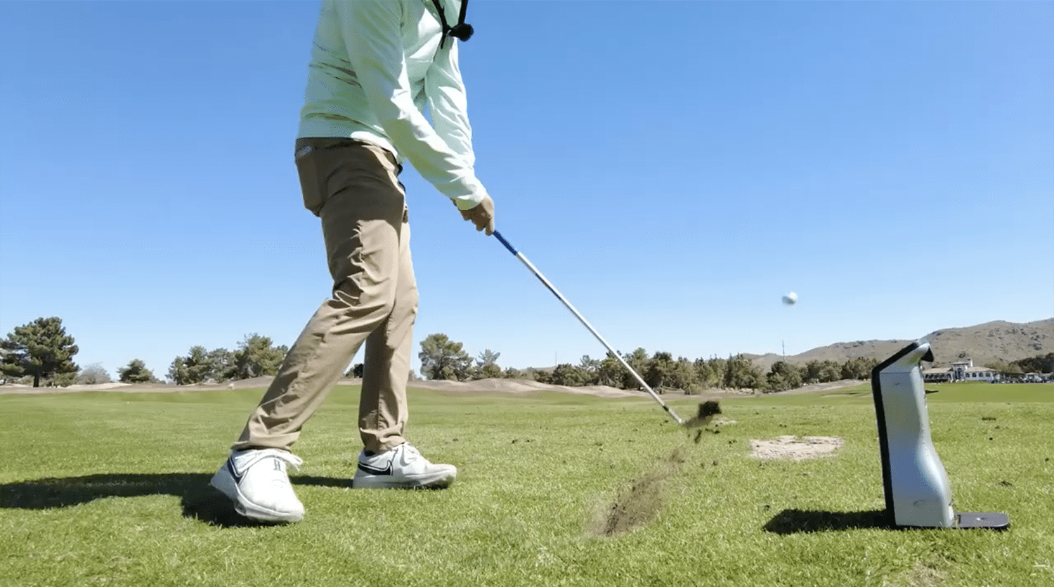Golfer hitting ball on sunny golf course