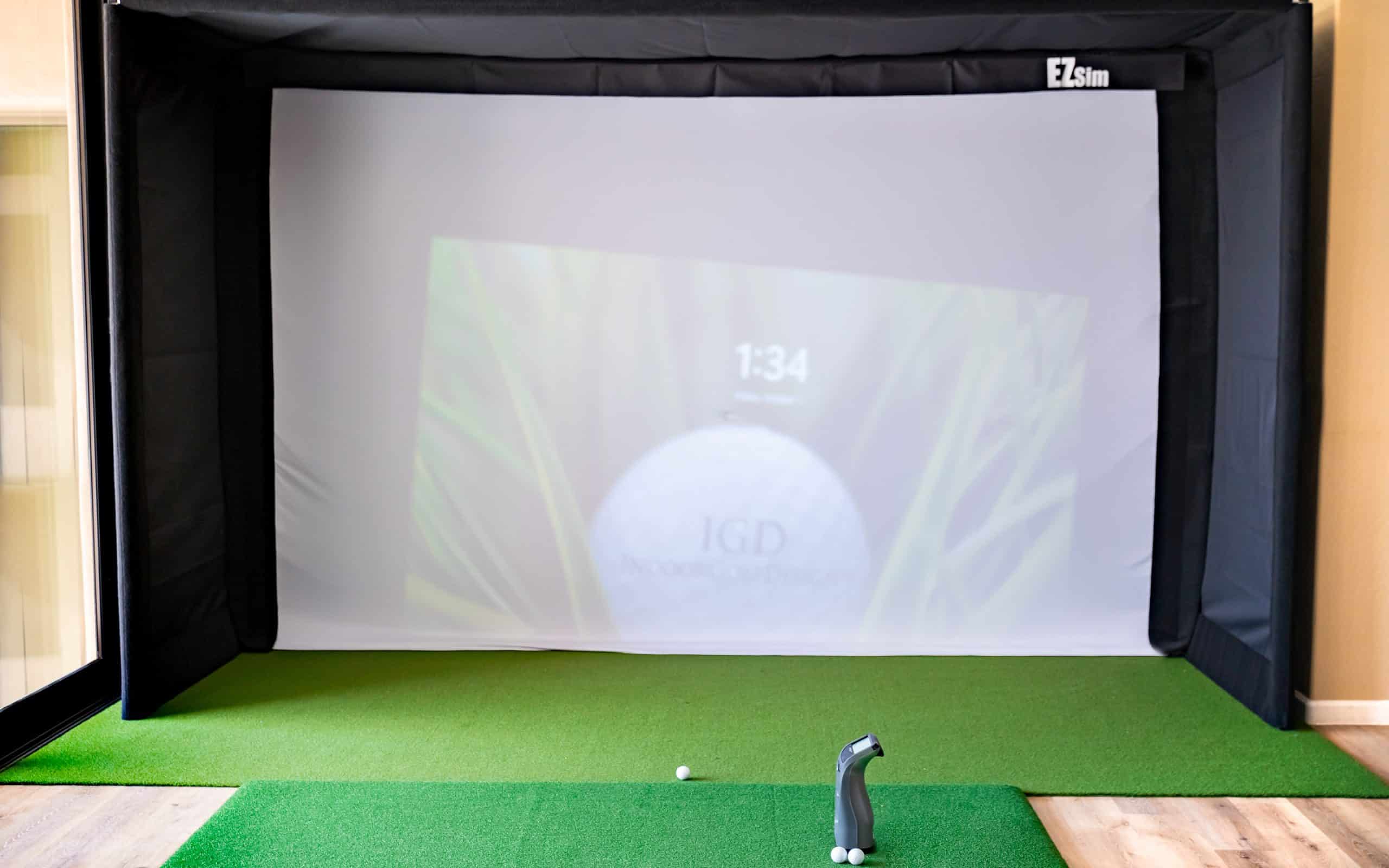 Indoor golf simulator with screen and turf mat