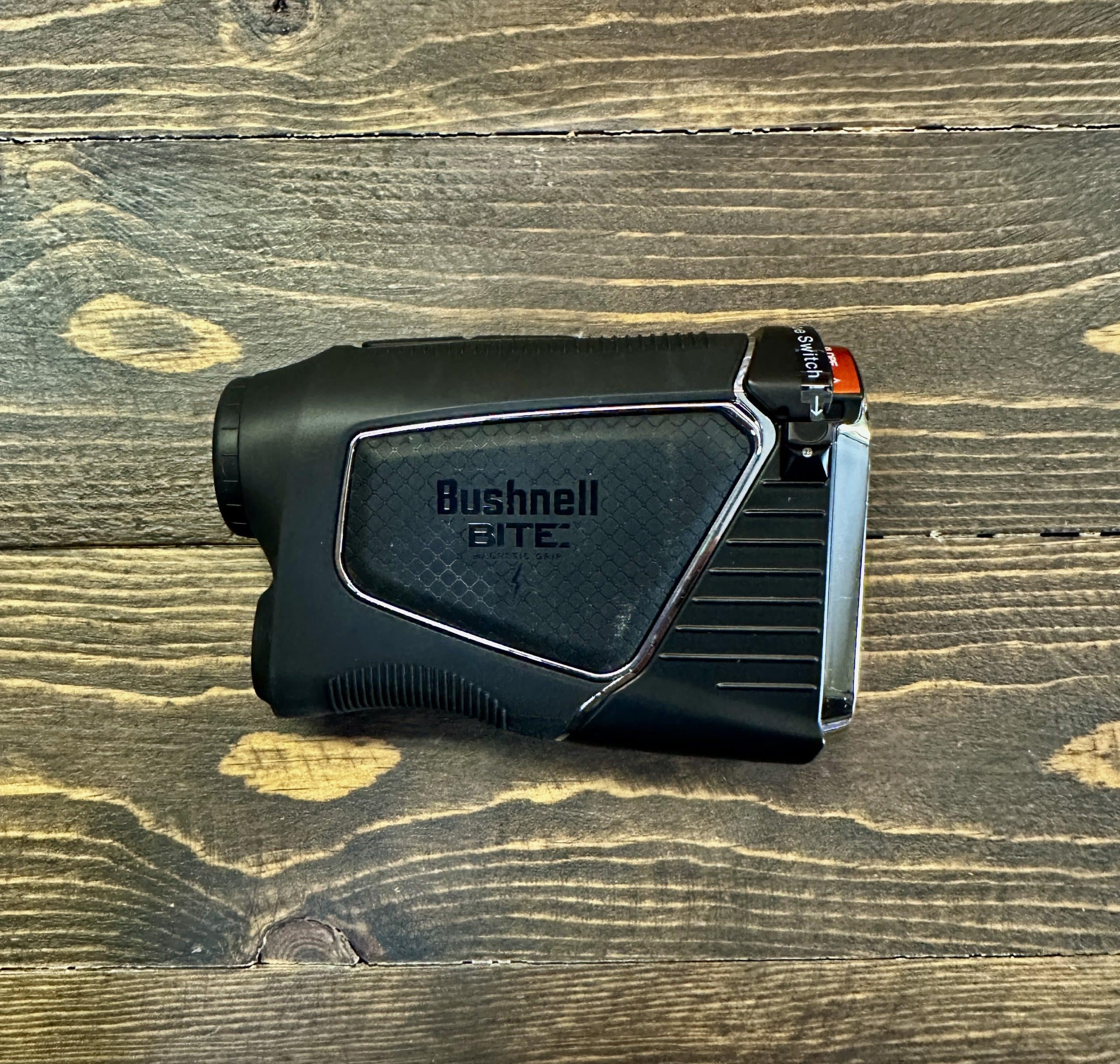 Bushnell golf rangefinder on wooden surface