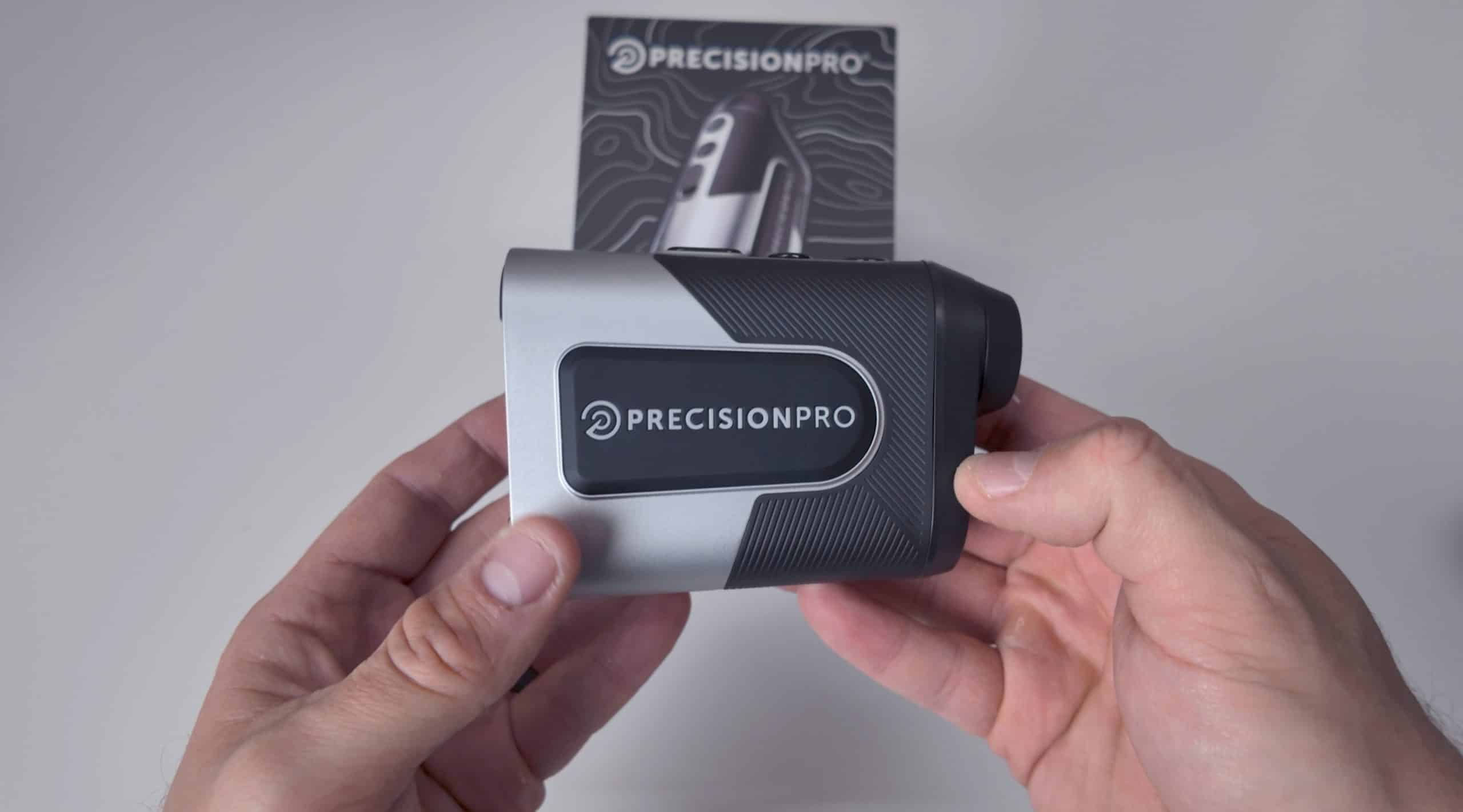 Person holding Precision Pro golf rangefinder