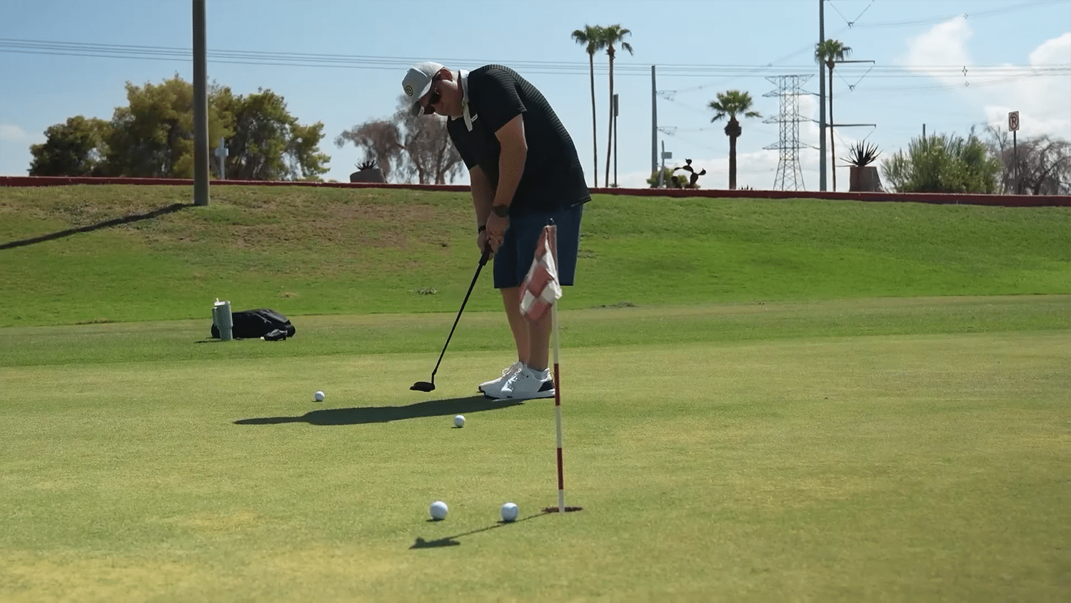 Golfer putting on sunny green course