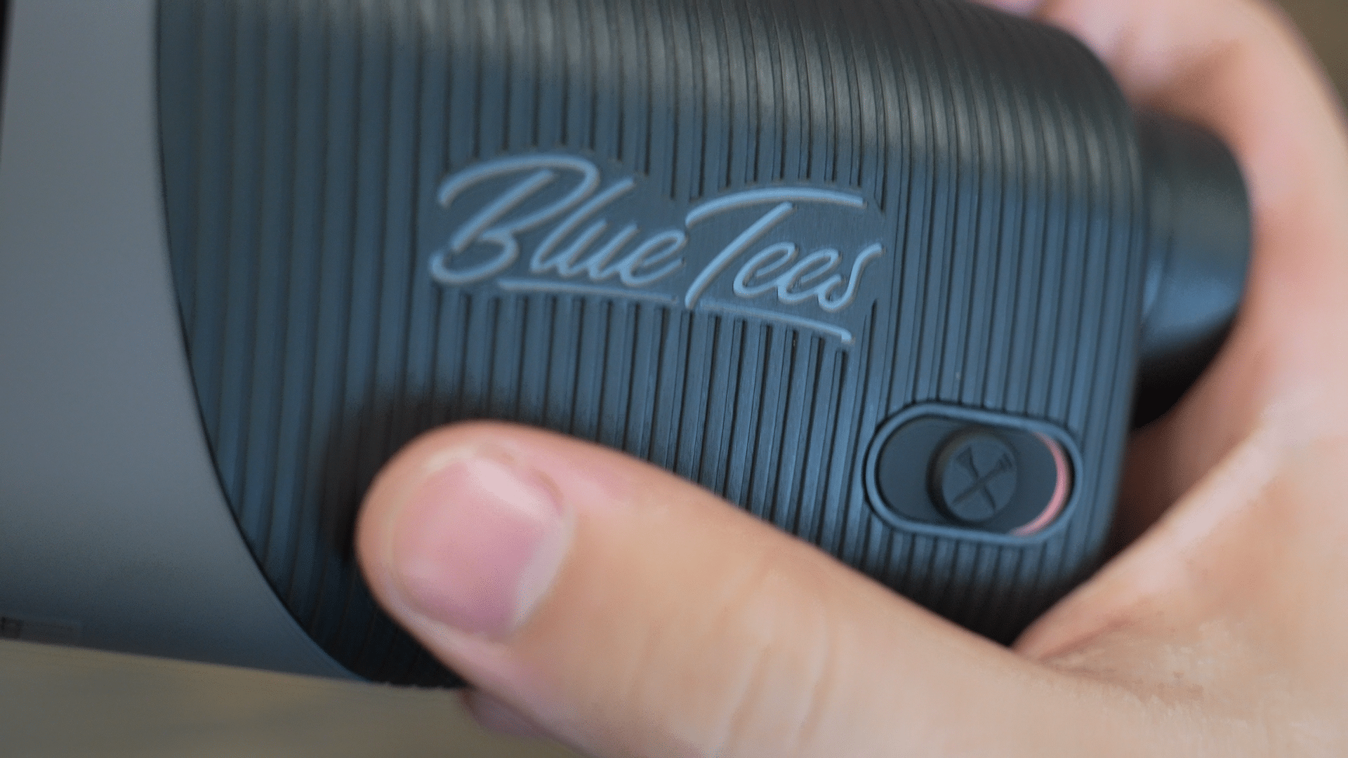 Hand holding Blue Tees golf rangefinder close-up