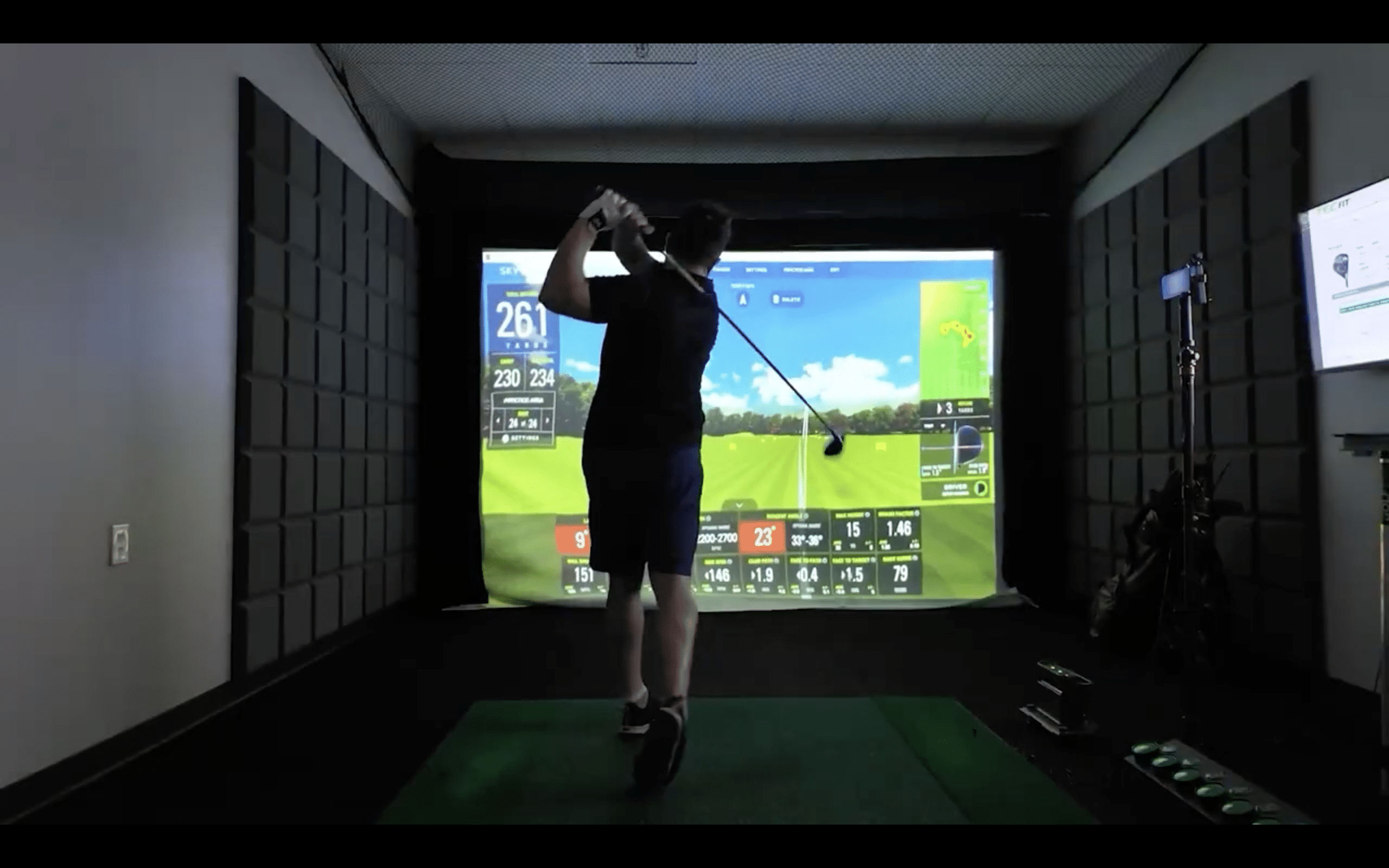 Golfer practicing swing in indoor golf simulator