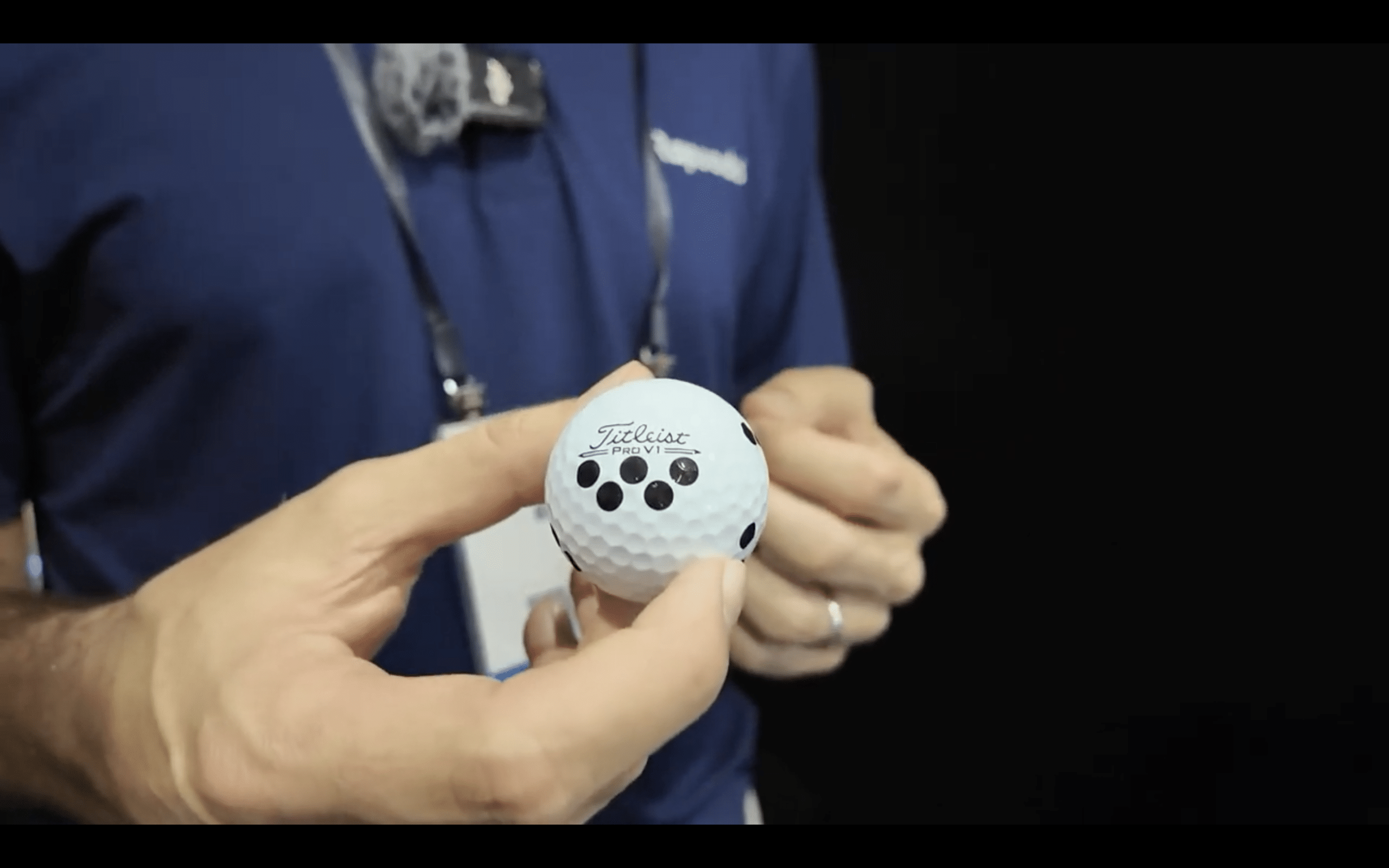 Person holding a Titleist Pro V1 golf ball