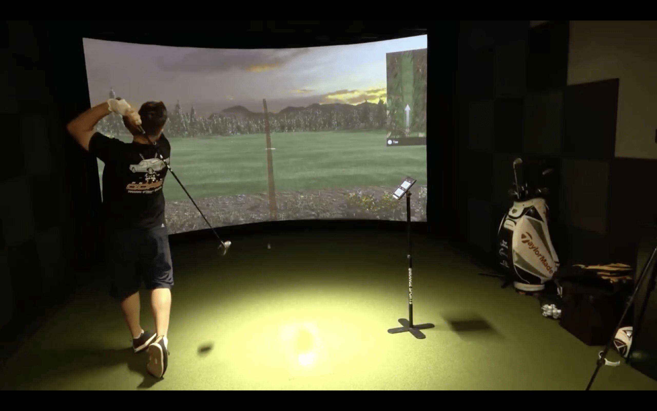 Man playing golf in indoor simulator room