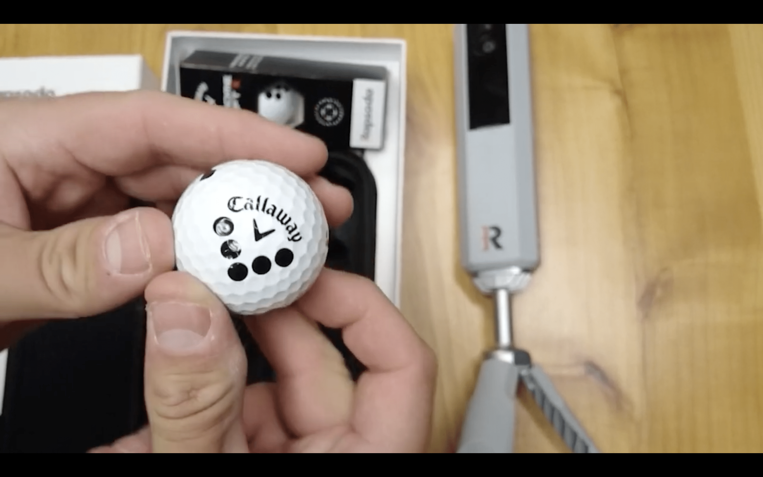 Hand holding Callaway golf ball close-up