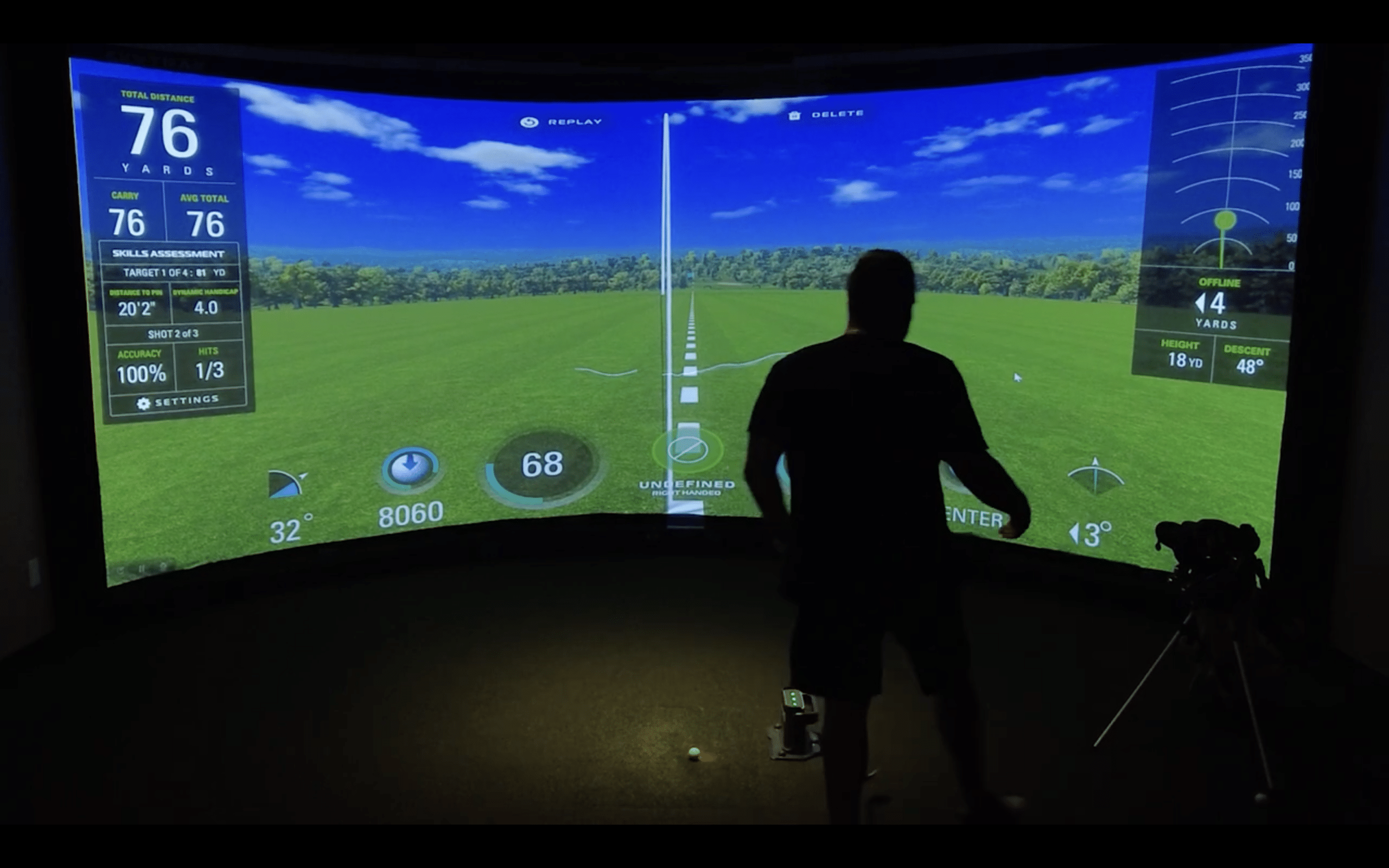Golfer practicing indoors on virtual golf simulator screen