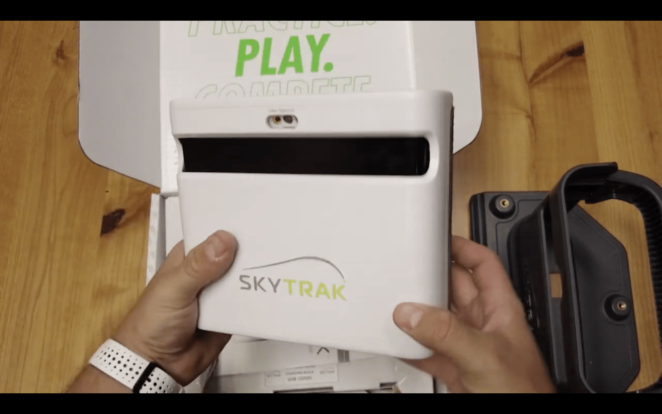 Person holding SkyTrak golf launch monitor device