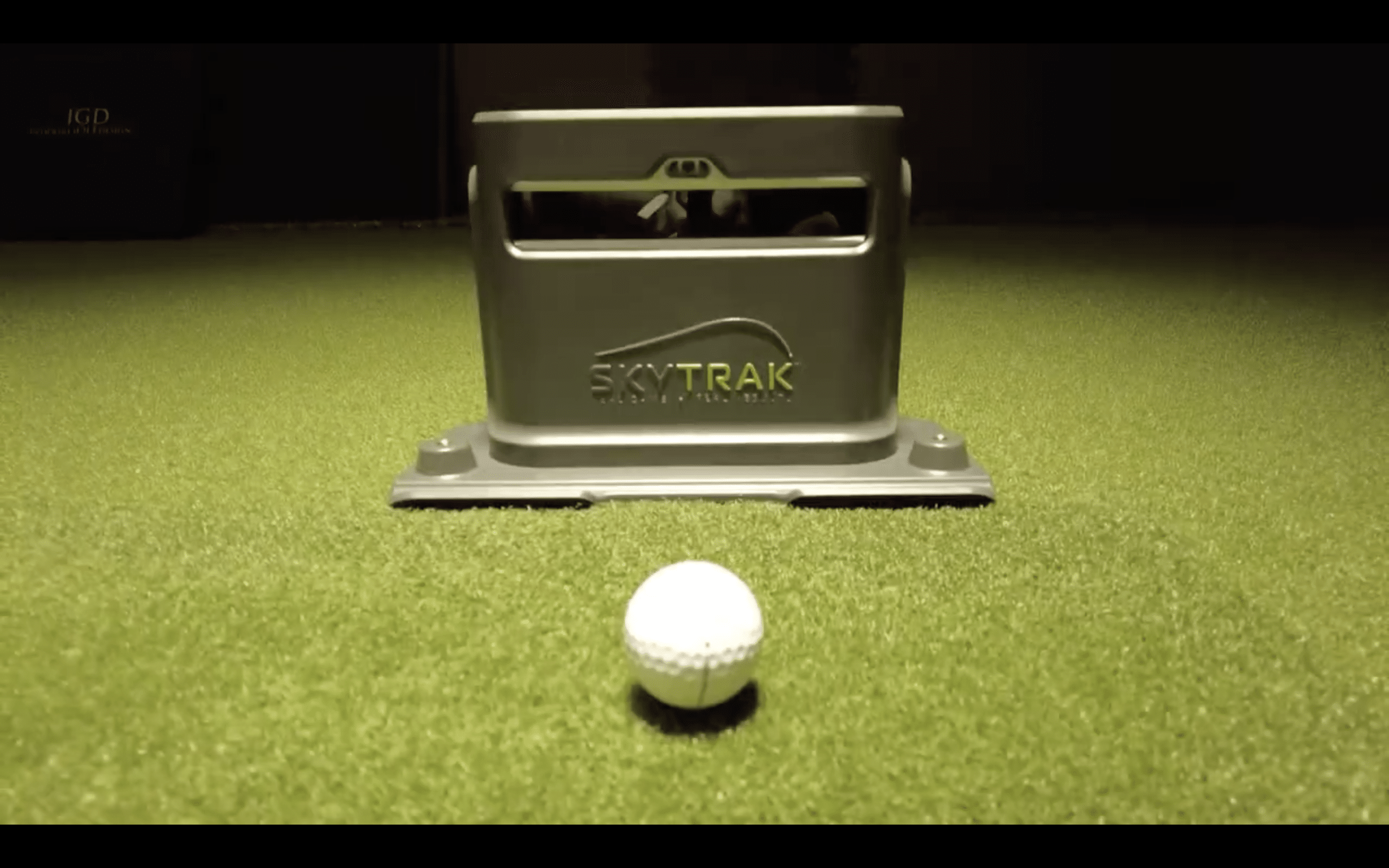Golf ball near SkyTrak launch monitor on turf