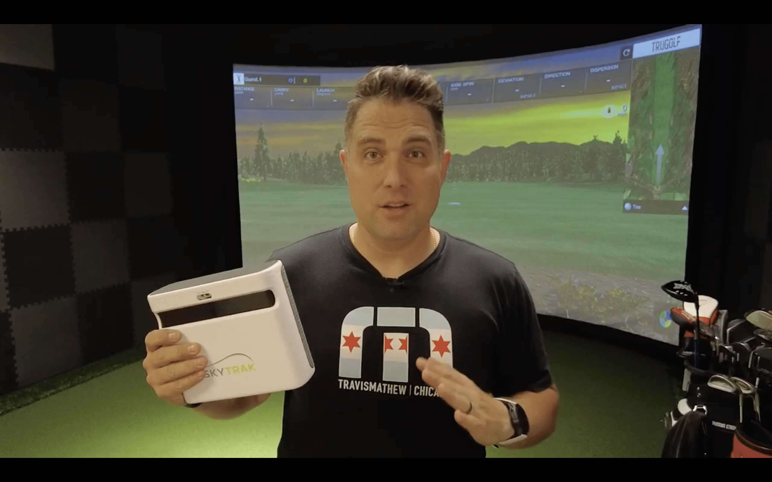 Man demonstrating SkyTrak golf launch monitor indoors