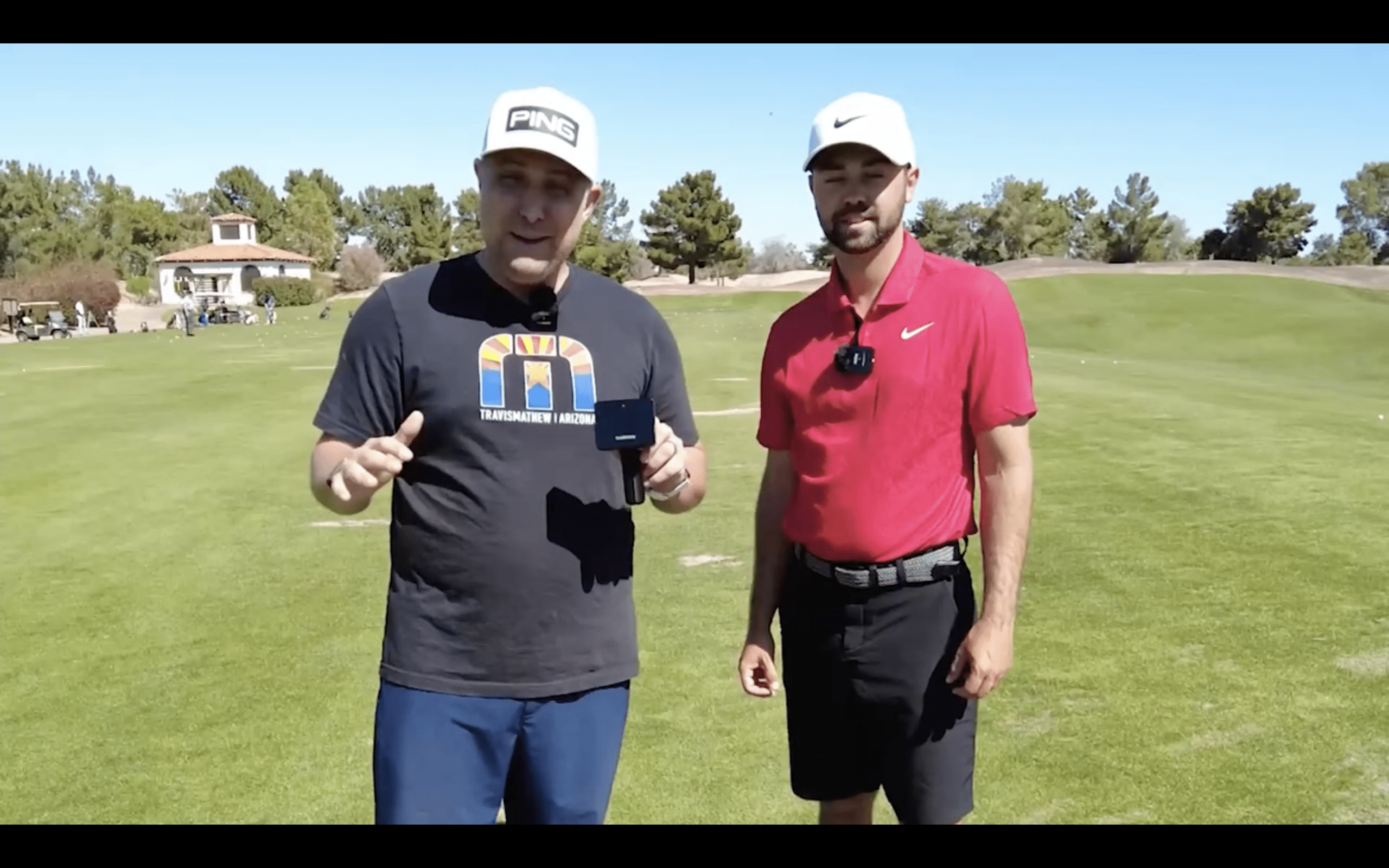 Two men standing on a sunny golf course.