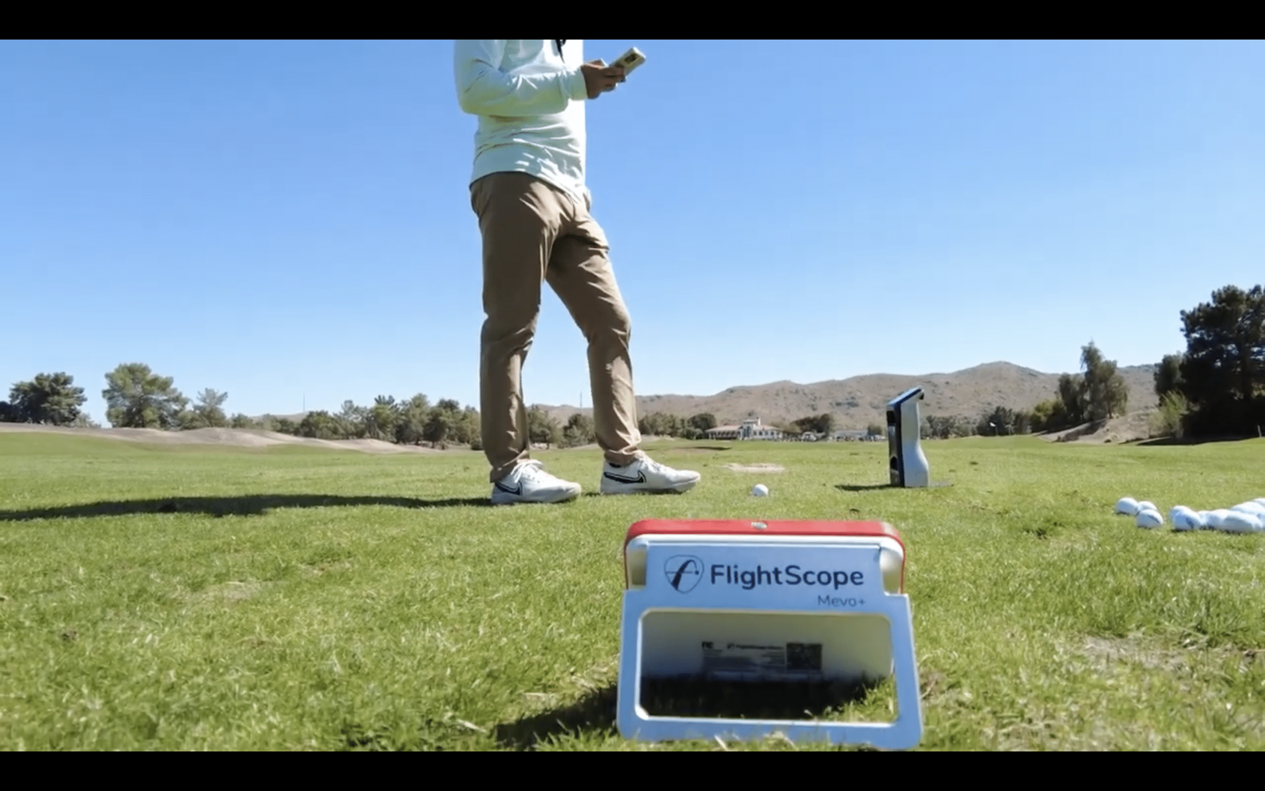 Golfer using FlightScope Mevo+ launch monitor outdoors