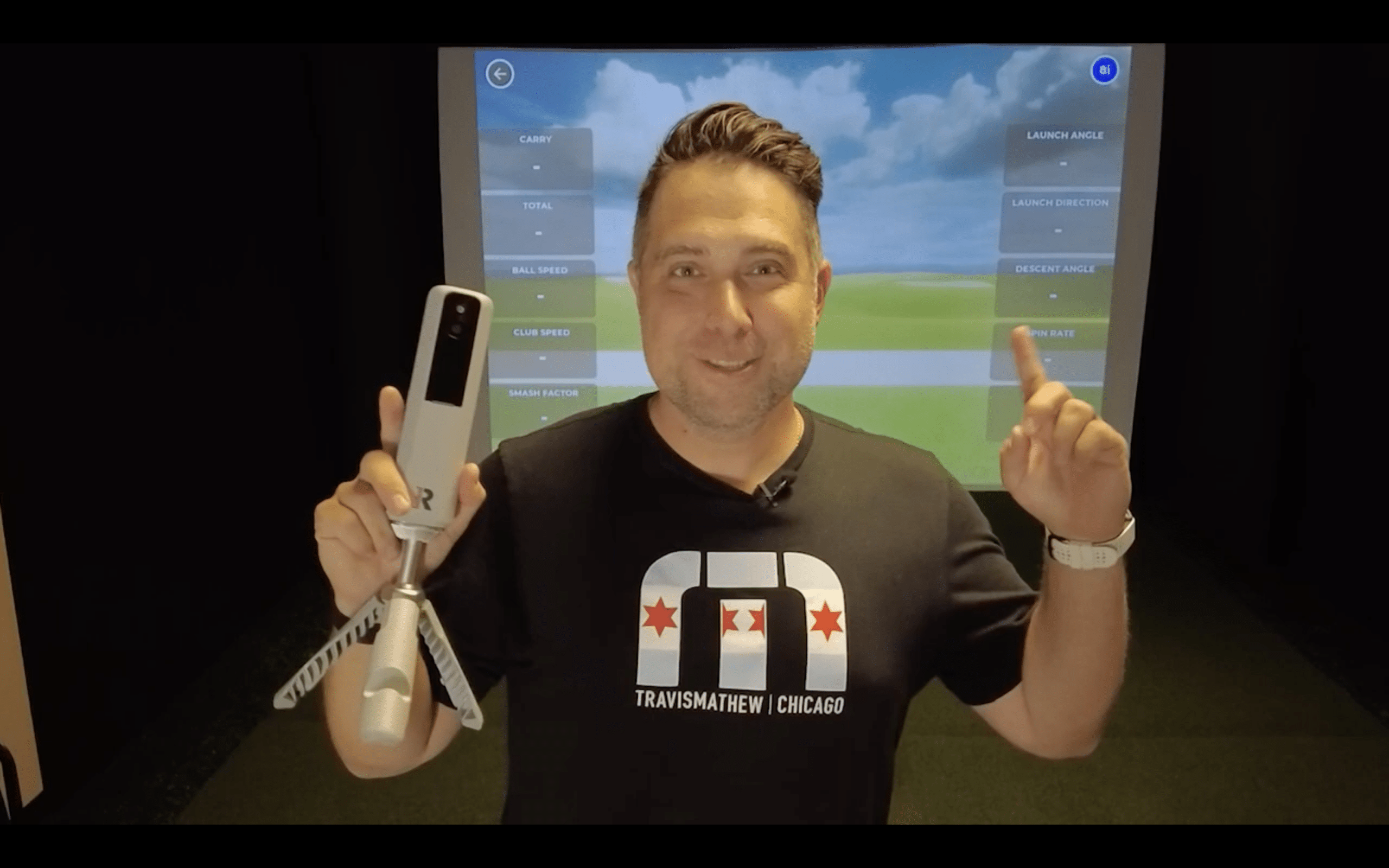 Man presenting golf simulator launch monitor indoors