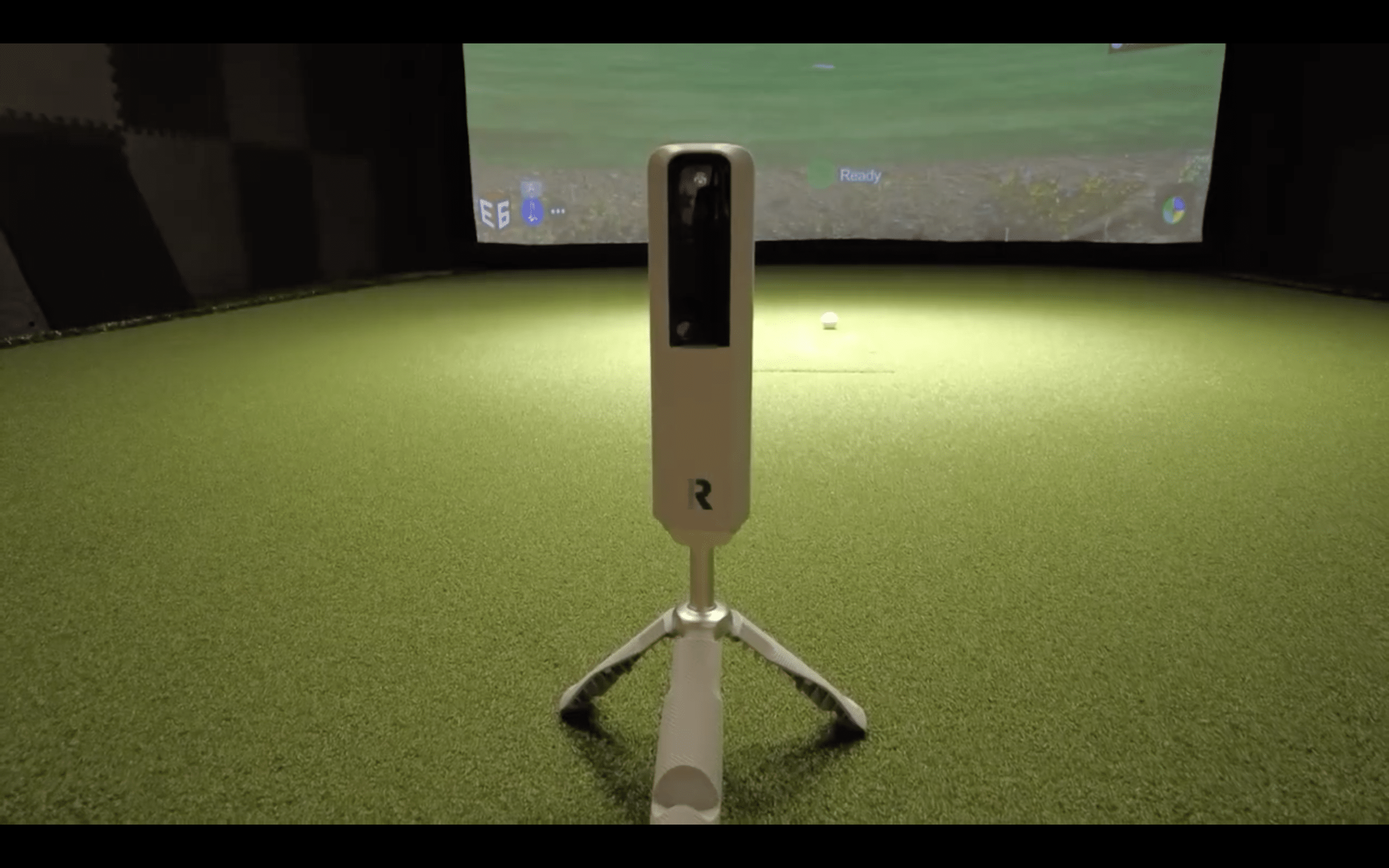 Golf simulator launch monitor on indoor green