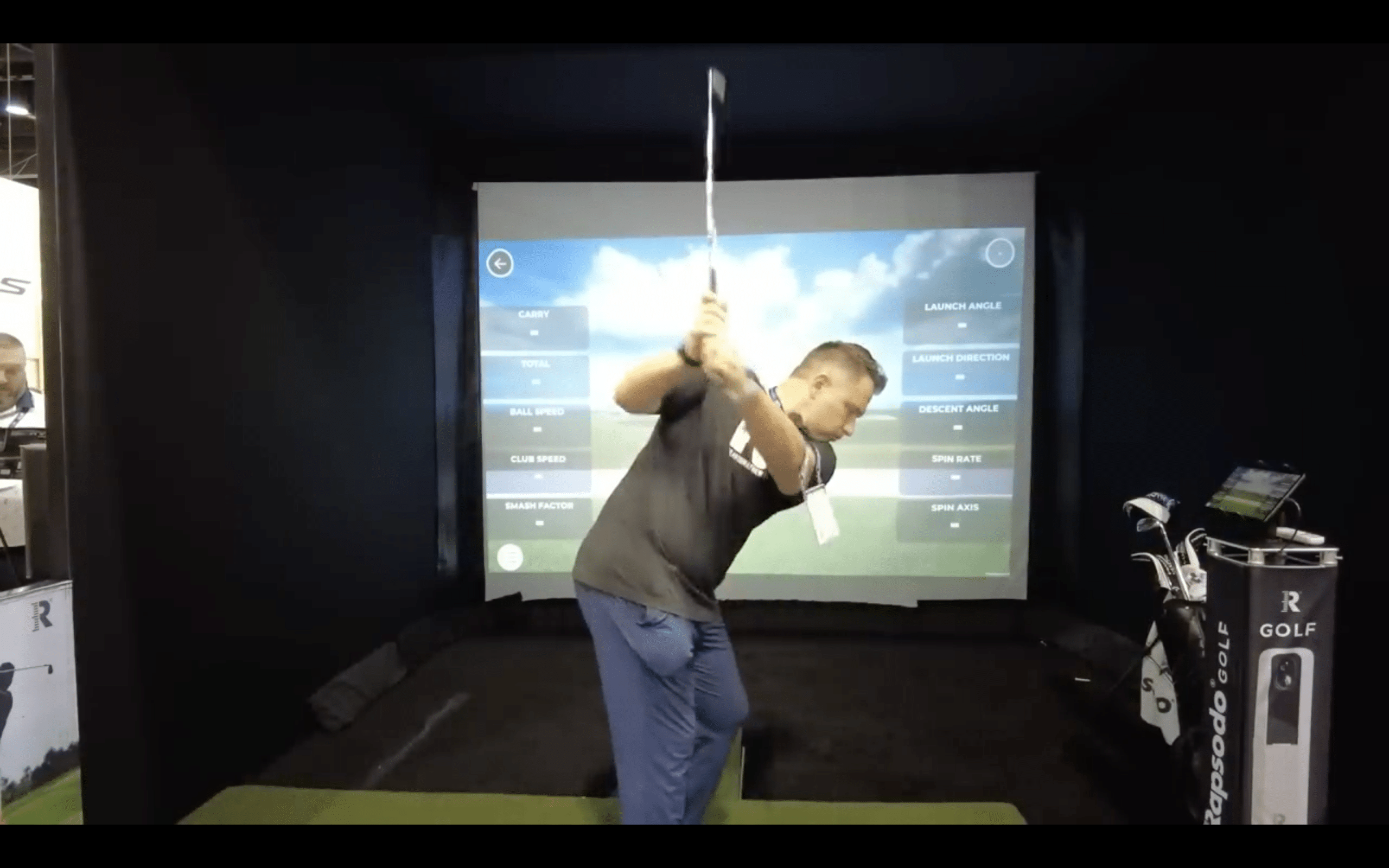 Golfer practicing swing with simulator screen data