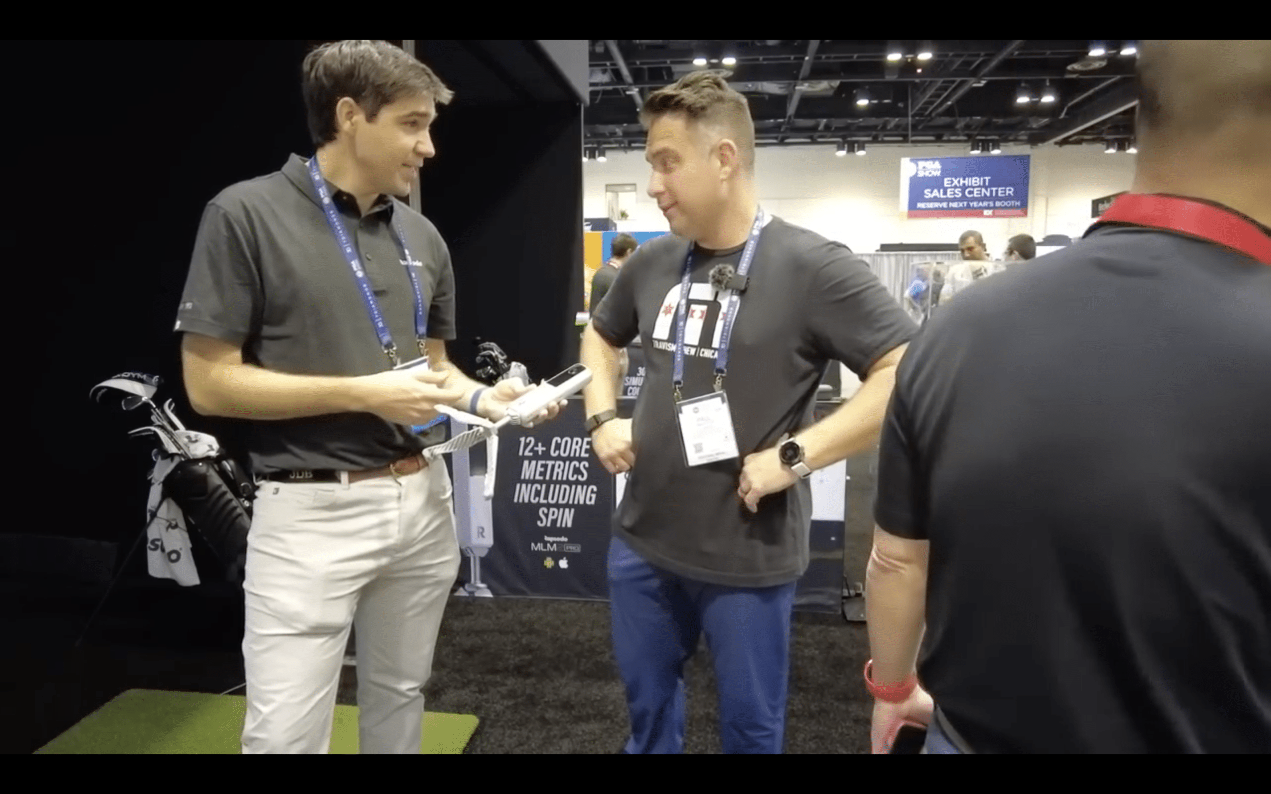 Two men talking at golf technology trade show