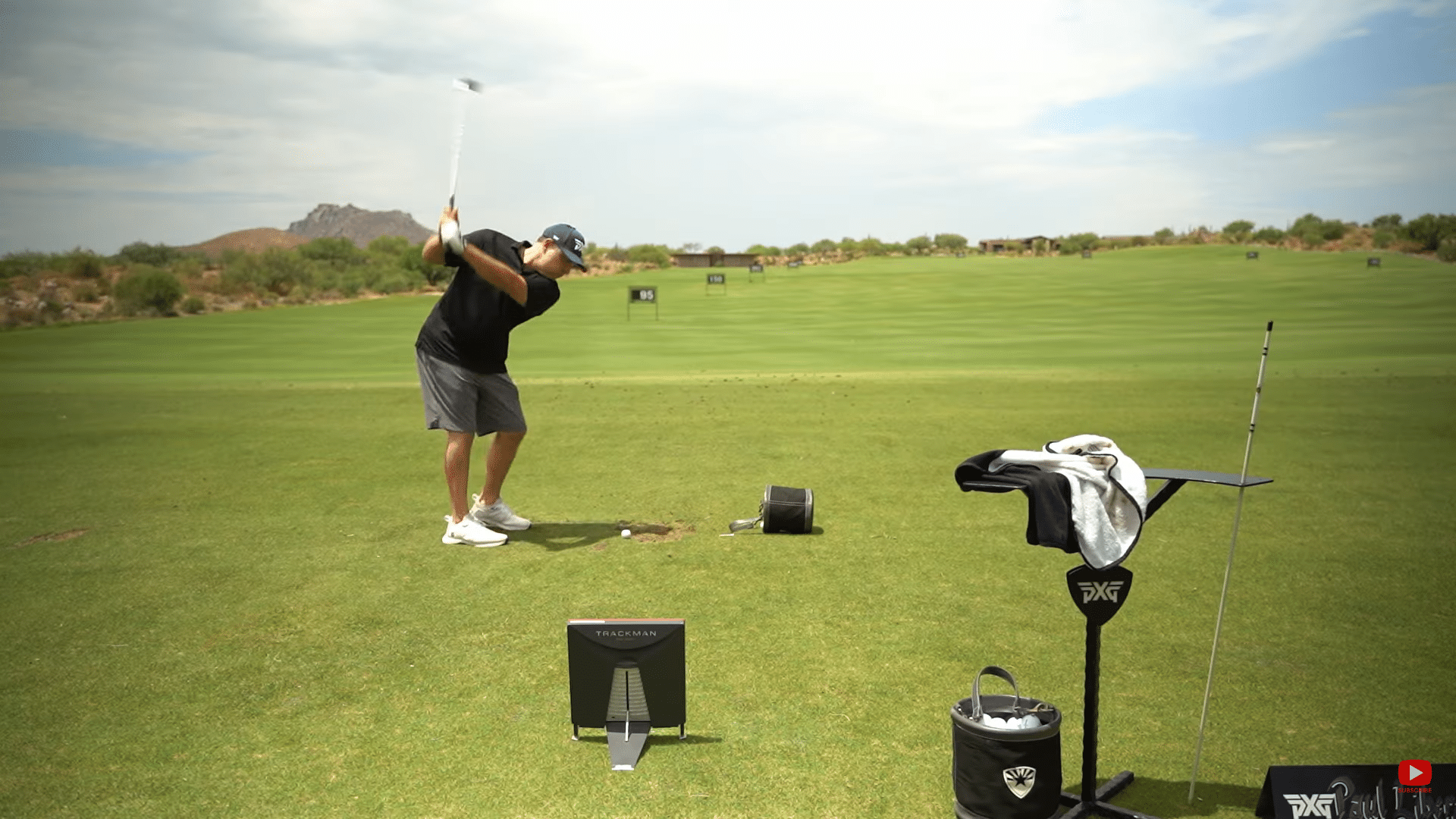 Golfer practicing swing on outdoor driving range