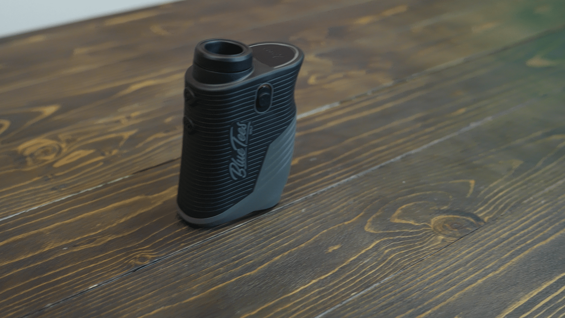 Black golf rangefinder on wooden surface