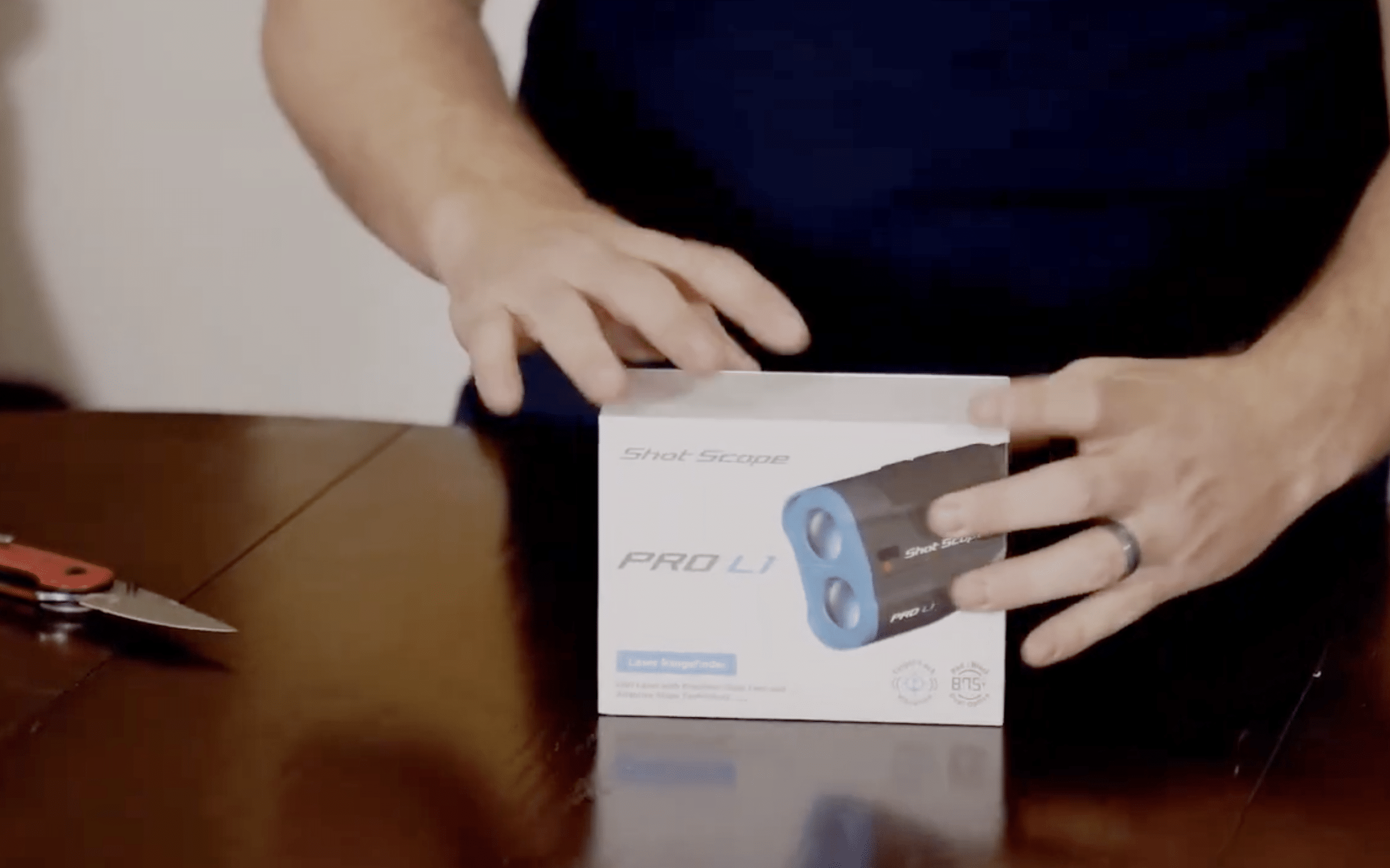 Person unboxing Shot Scope Pro L1 rangefinder
