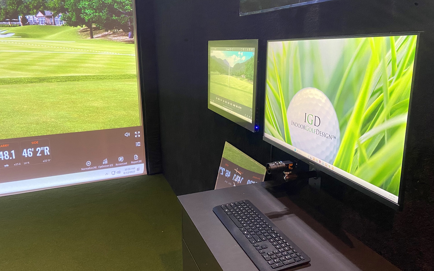 Indoor golf simulator with monitors and keyboard