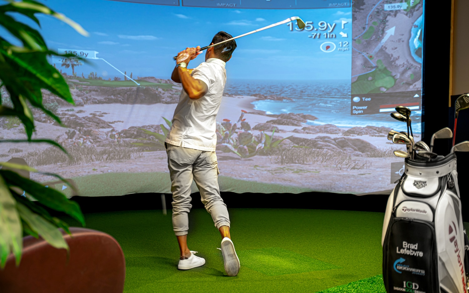Man playing golf on indoor simulator screen
