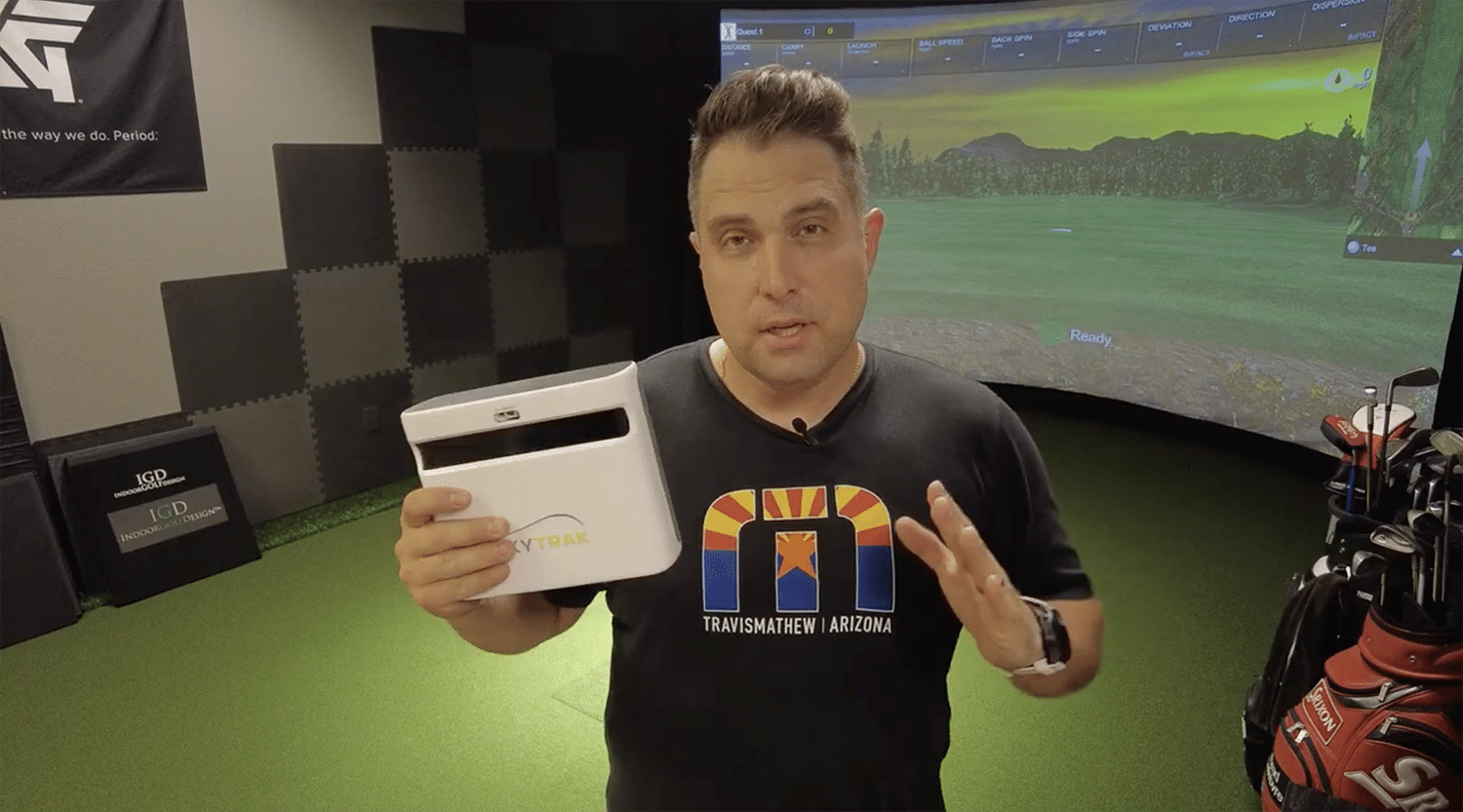 Man demonstrating SkyTrak golf launch monitor indoors