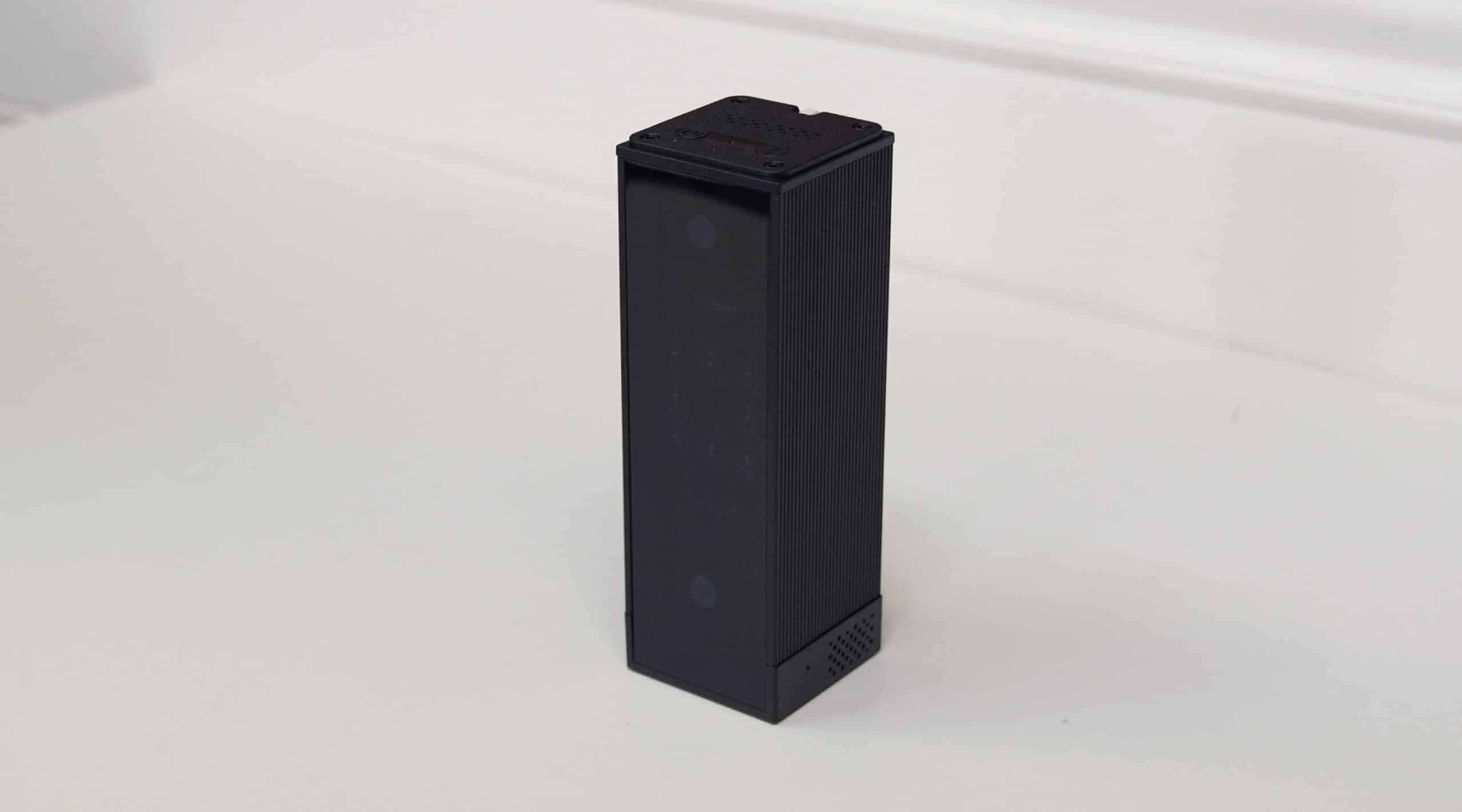Black portable Bluetooth speaker on white surface