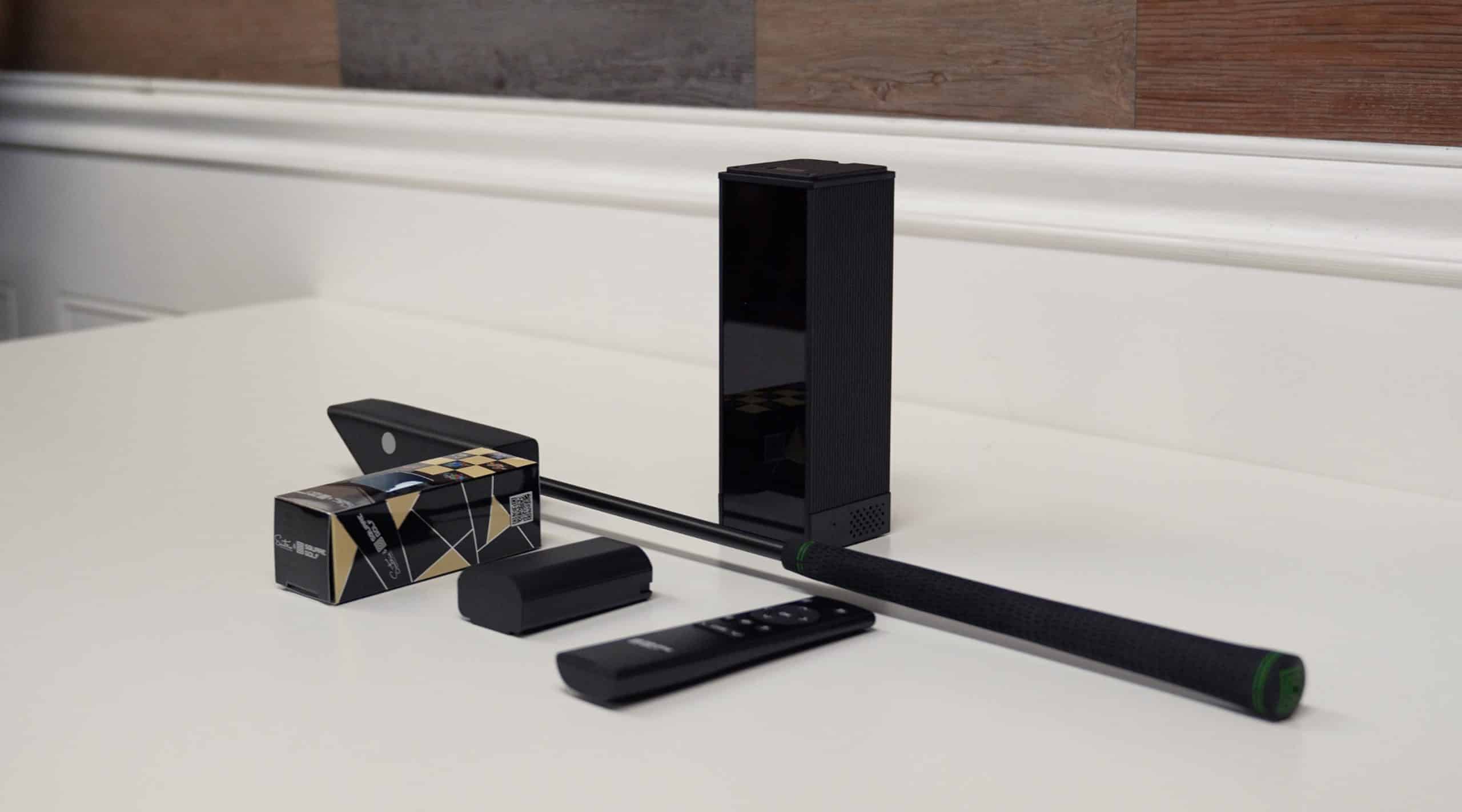 Golf swing analyzer device with accessories on table