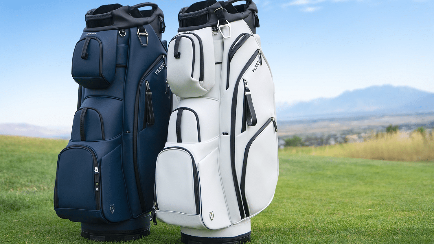 Navy and white golf bags on grassy course