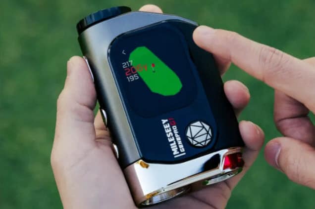 Hand holding golf rangefinder with distance display