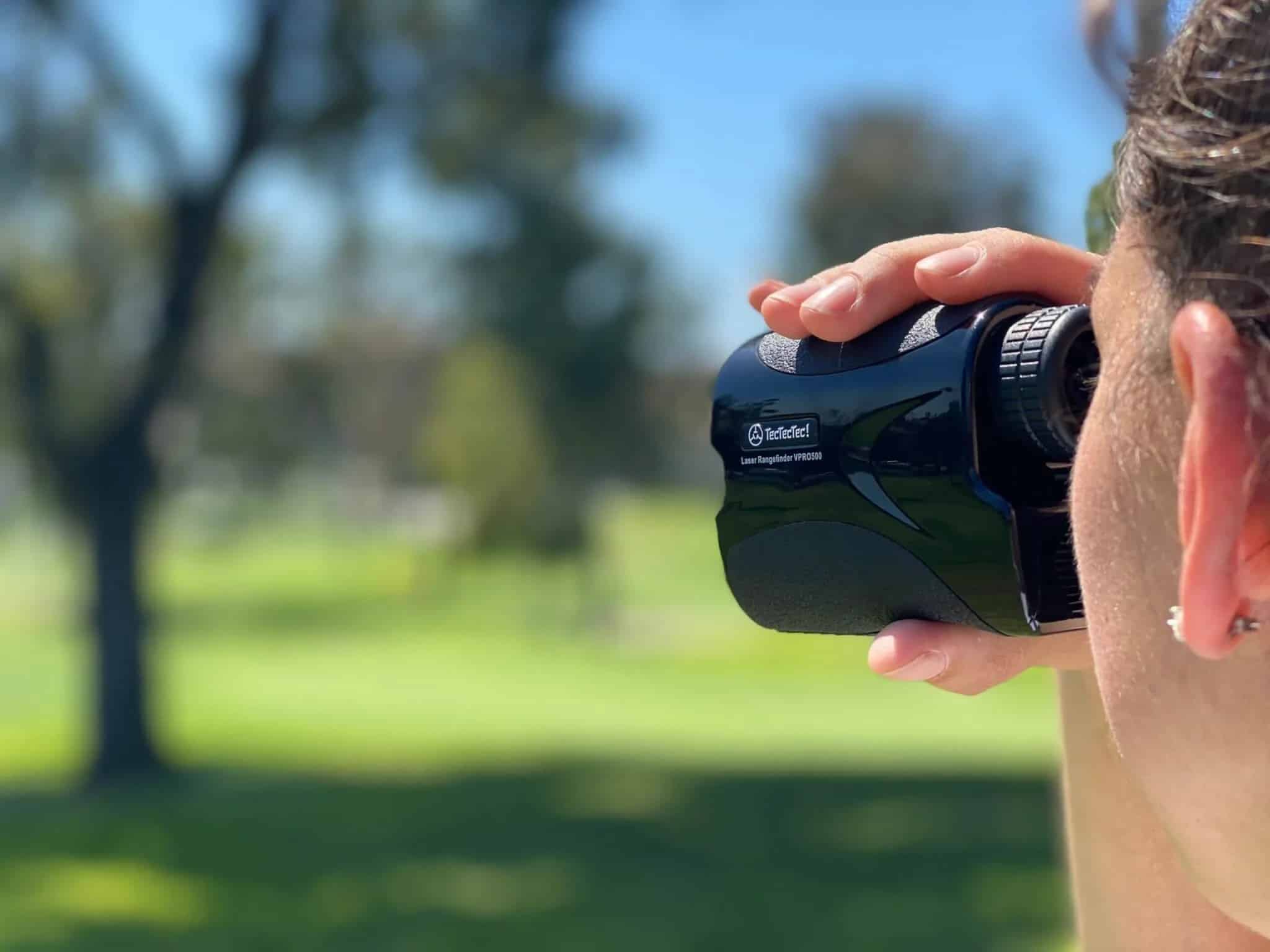 Person using a golf rangefinder outdoors