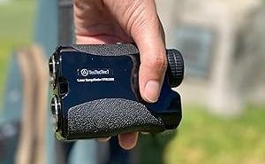 Person holding a laser rangefinder outdoors